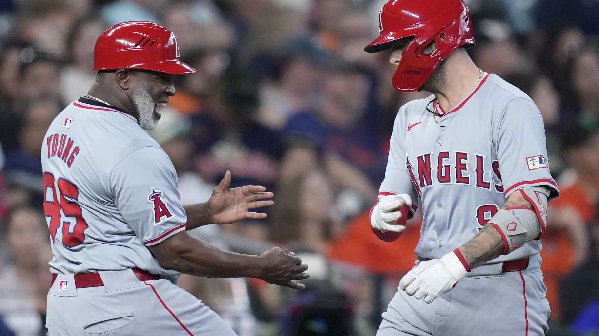 Los Angeles Angels' Zach Neto, right, is congratulated by third base coach Eric Young Sr., left, after hitting a solo home run during the eighth inning of a baseball game against the Houston Astros, Sunday, Sept. 22, 2024, in Houston.