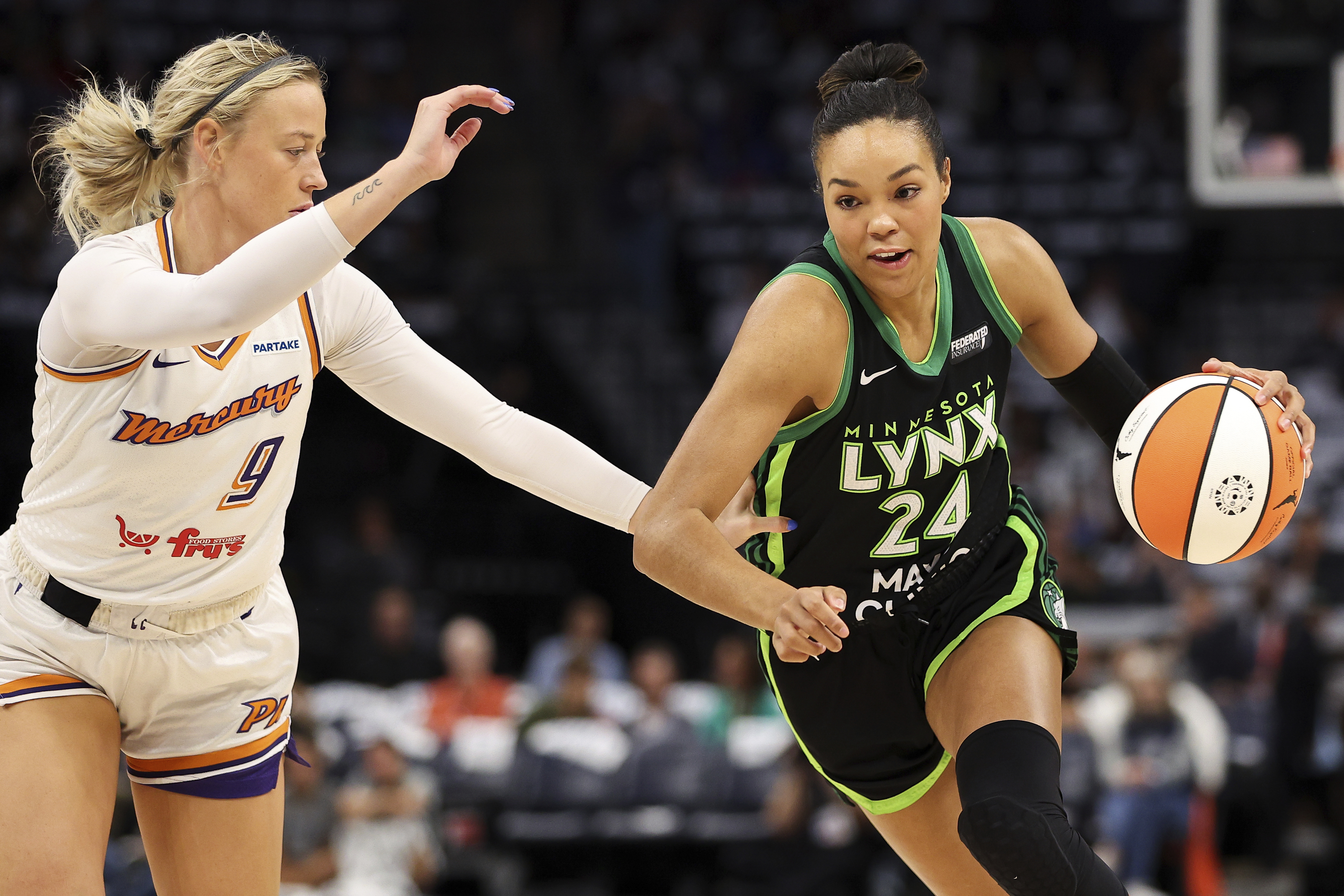 Minnesota Lynx forward Napheesa Collier, right, works around Phoenix Mercury guard Sophie Cunningham, left, during the first half of Game 1 of a WNBA basketball first-round playoff game, Sunday, Sept. 22, 2024, in Minneapolis. 