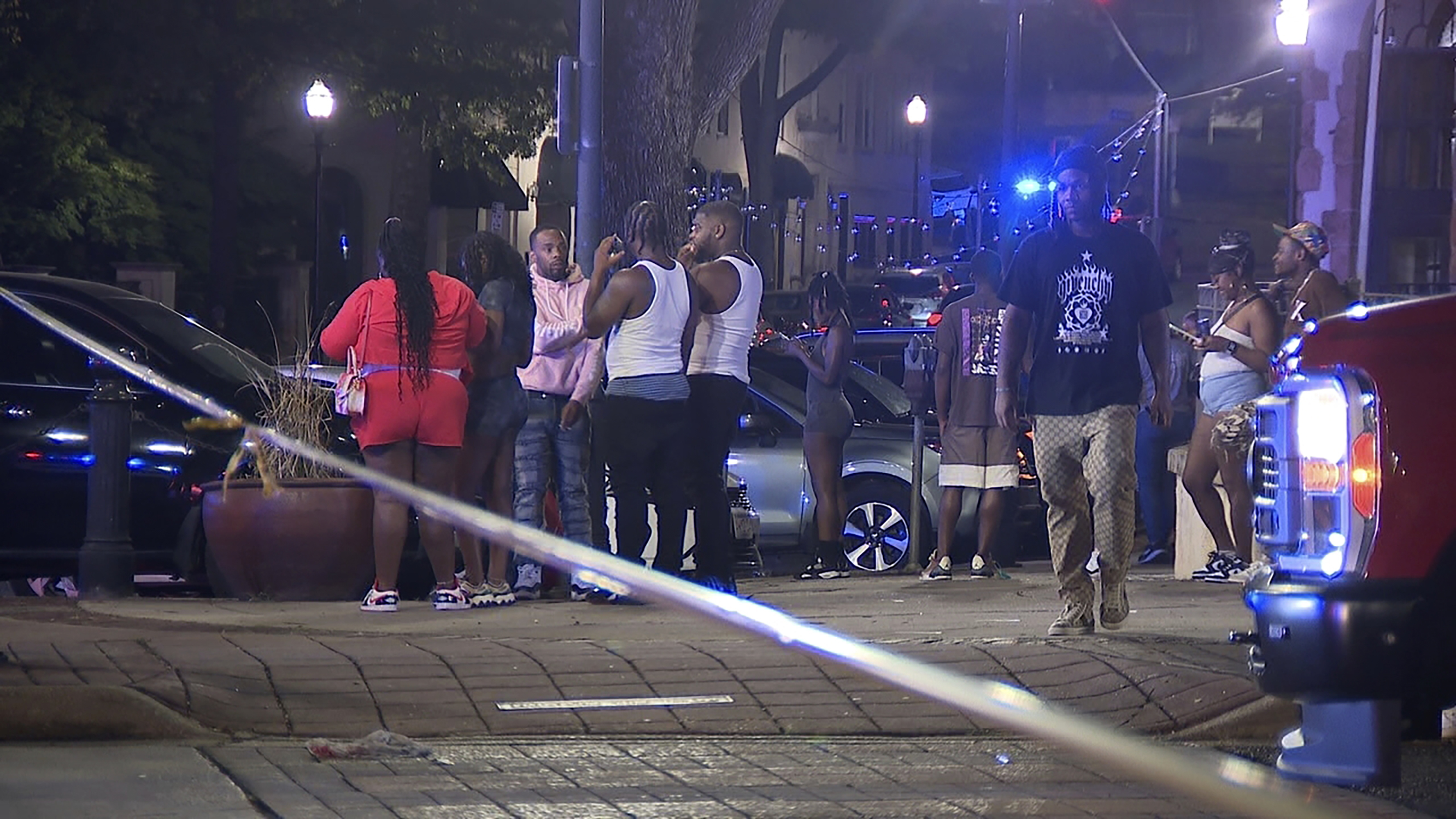 This image provided by WBMA shows bystanders near the scene of a shooting in Birmingham, Ala., Sunday. The police is pleading with members of the public for information leading to arrests of those involved.