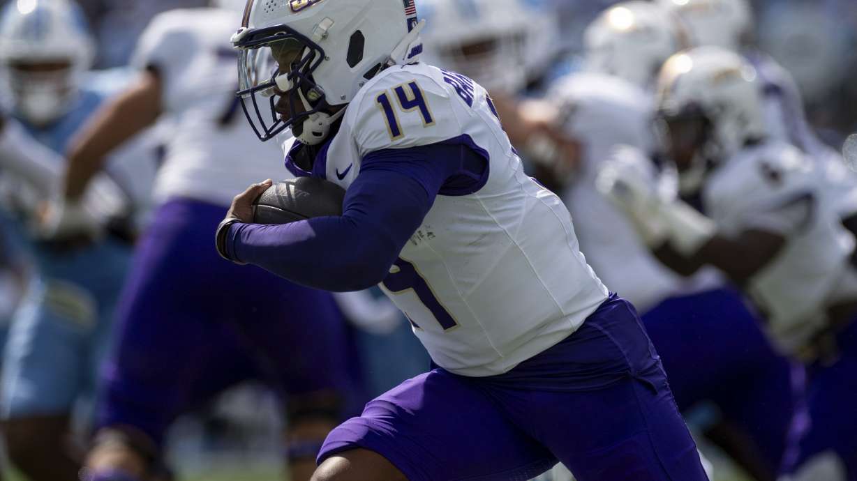 James Madison quarterback Alonza Barnett III (14) drives the ball around North Carolina defense during the first half of an NCAA college football game in Chapel Hill, N.C., Saturday, Sept. 21, 2024.