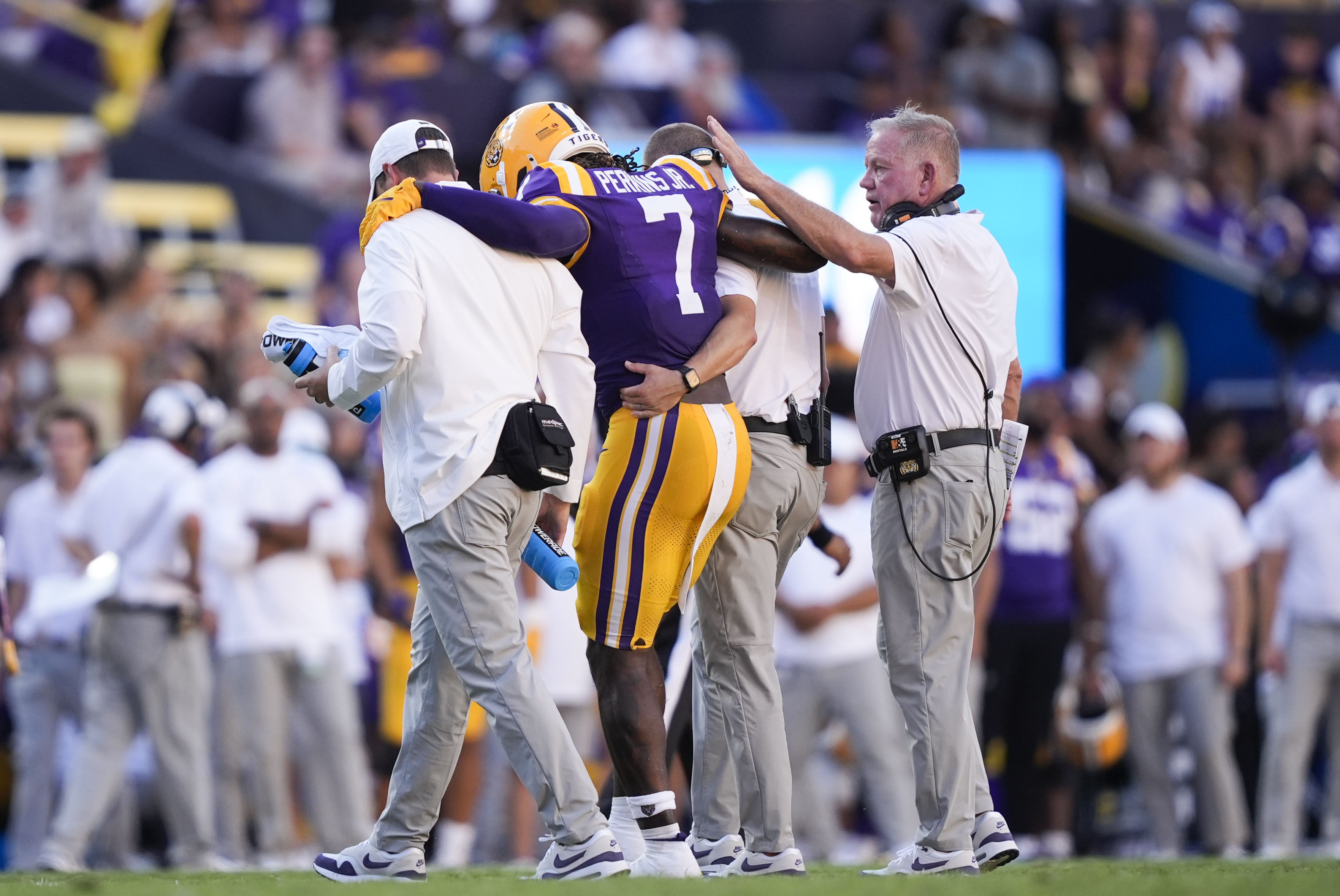 LSU head coach Brian Kelly, right, pats linebacker Harold Perkins Jr. (7) as he is helped off the field after being injured in the second half of an NCAA college football game against UCLA in Baton Rouge, La., Saturday, Sept. 21, 2024. LSU won 34-17. 