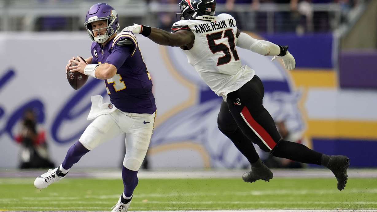 Minnesota Vikings quarterback Sam Darnold (14) runs from Houston Texans defensive end Will Anderson Jr. (51) during the second half of an NFL football game, Sunday, Sept. 22, 2024, in Minneapolis.