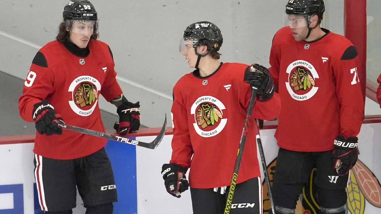 Chicago Blackhawks' Tyler Bertuzzi, left, talks with Connor Bedard, center, and Taylor Hall during the team's NHL hockey training camp Thursday, Sept. 19, 2024, in Chicago.