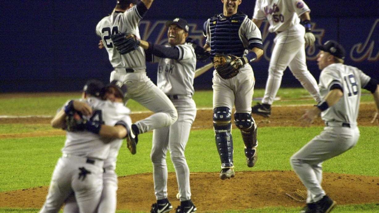 FILE - New York Yankees first baseman Tino Martinez (24) jumps into the arms of pitcher Mariano Rivera as catcher Jorge Posada, third from right, Scott Brosius (18) and others celebrate after defeating the New York Mets in Game 5 of the World Series 4-2 to become the 2000 World Series Champions, Oct. 26, 2000, at New York's Shea Stadium.