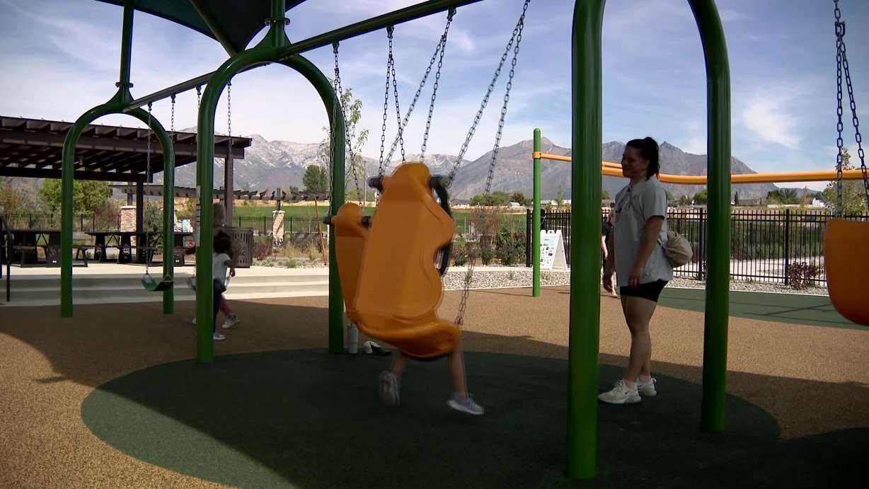 Kids swing on the new swing sets in Lehi Park.