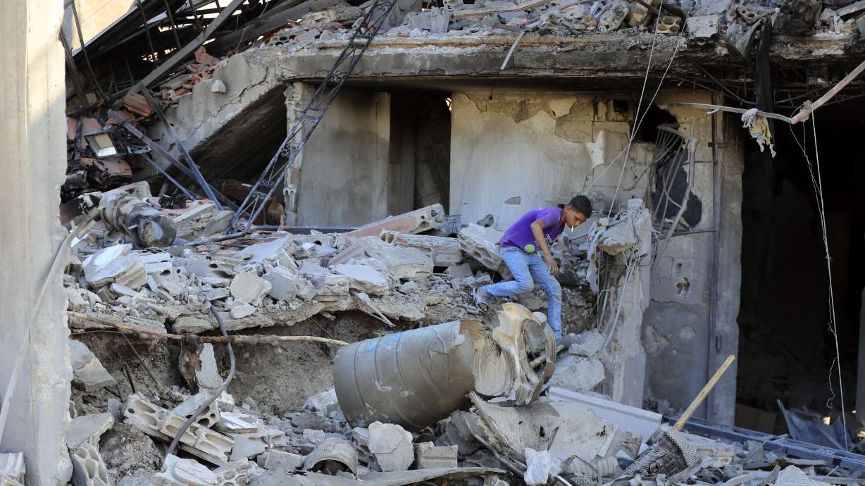 A boy checks the damage to a building hit in an Israeli airstrike in the southern village of Akbieh, Lebanon, Tuesday. Israel and Hezbollah are trading strikes again as the death toll from a massive Israeli bombardment is nearly 560 people.