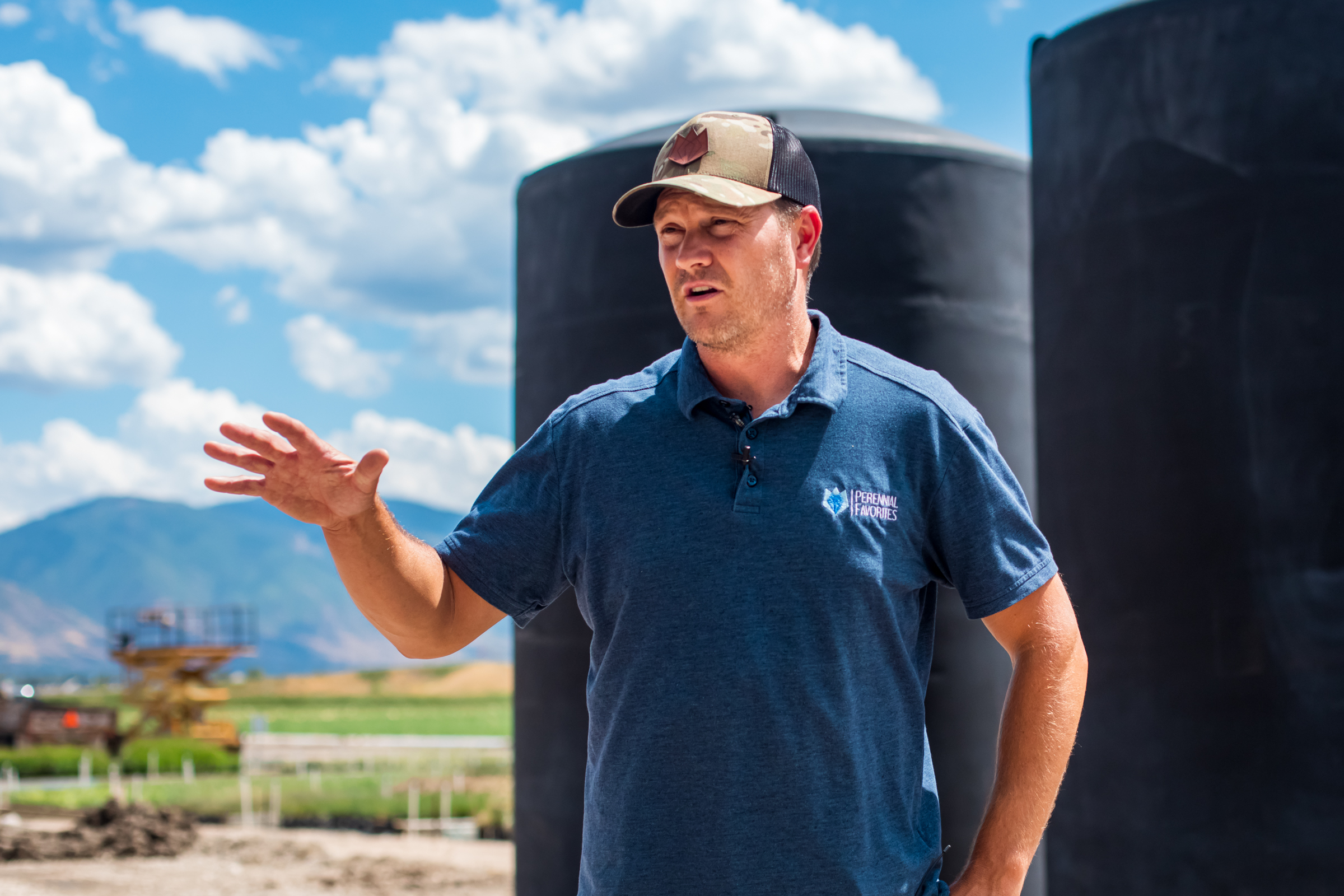 Cort Cox, head annual grower for Perennial Favorites, talks about the company's water reclamation system while standing in front of its three large tanks on Aug. 20. The tanks can hold up to 15,000 gallons of water at any given time.