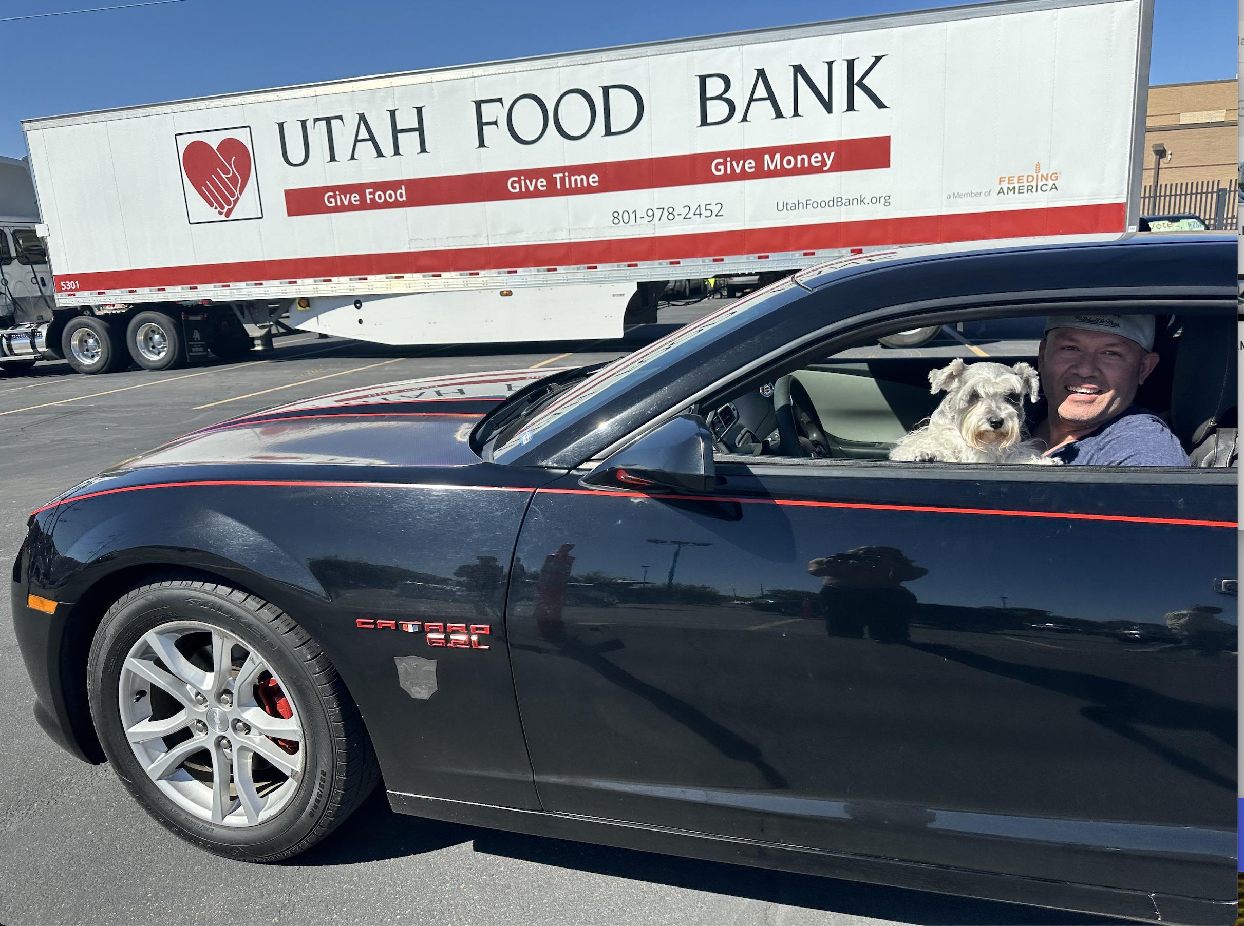 A participant and his dog are seen at Utah Food Bank's drive-thru distribution for pets in need.