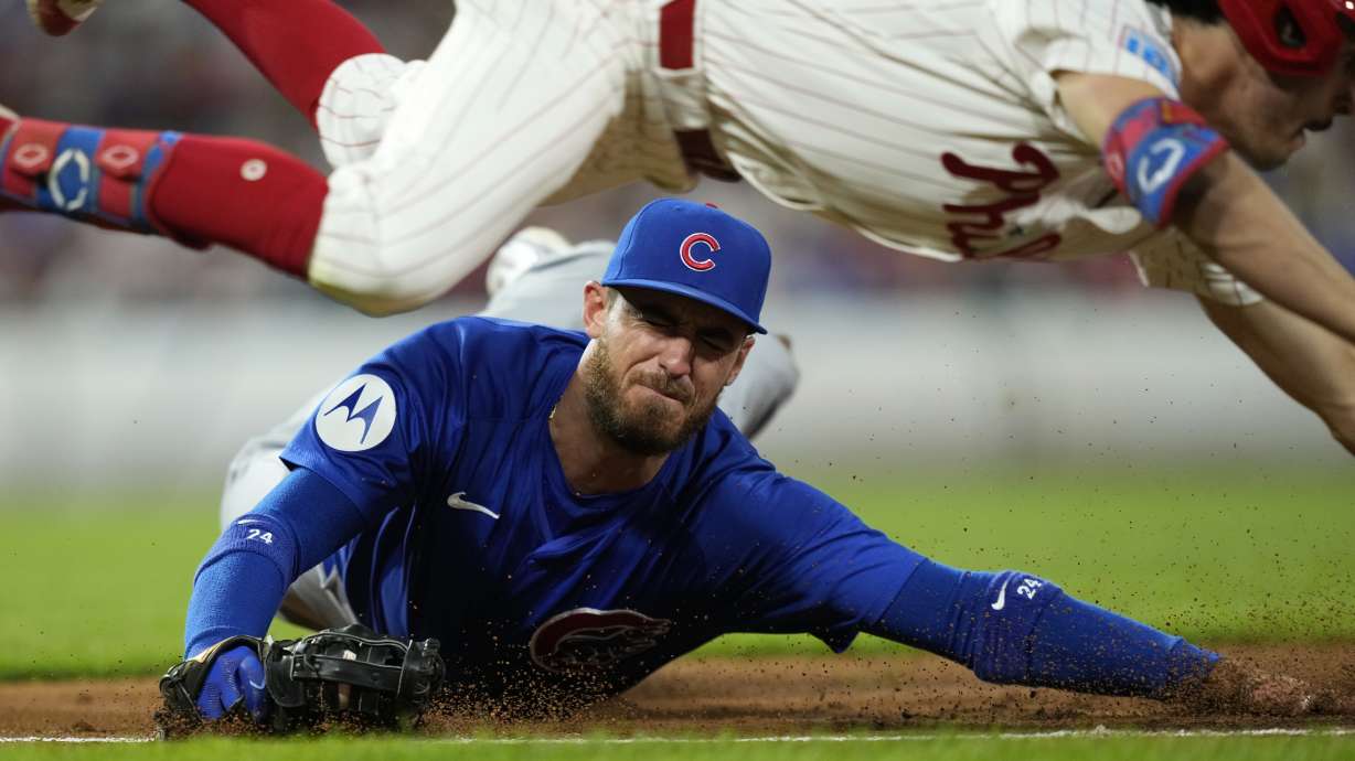 Chicago Cubs first baseman Cody Bellinger, bottom, cannot tag Philadelphia Phillies' Garrett Stubbs after Stubbs' run-scoring bunt single during the second inning of a baseball game, Tuesday, Sept. 24, 2024, in Philadelphia.