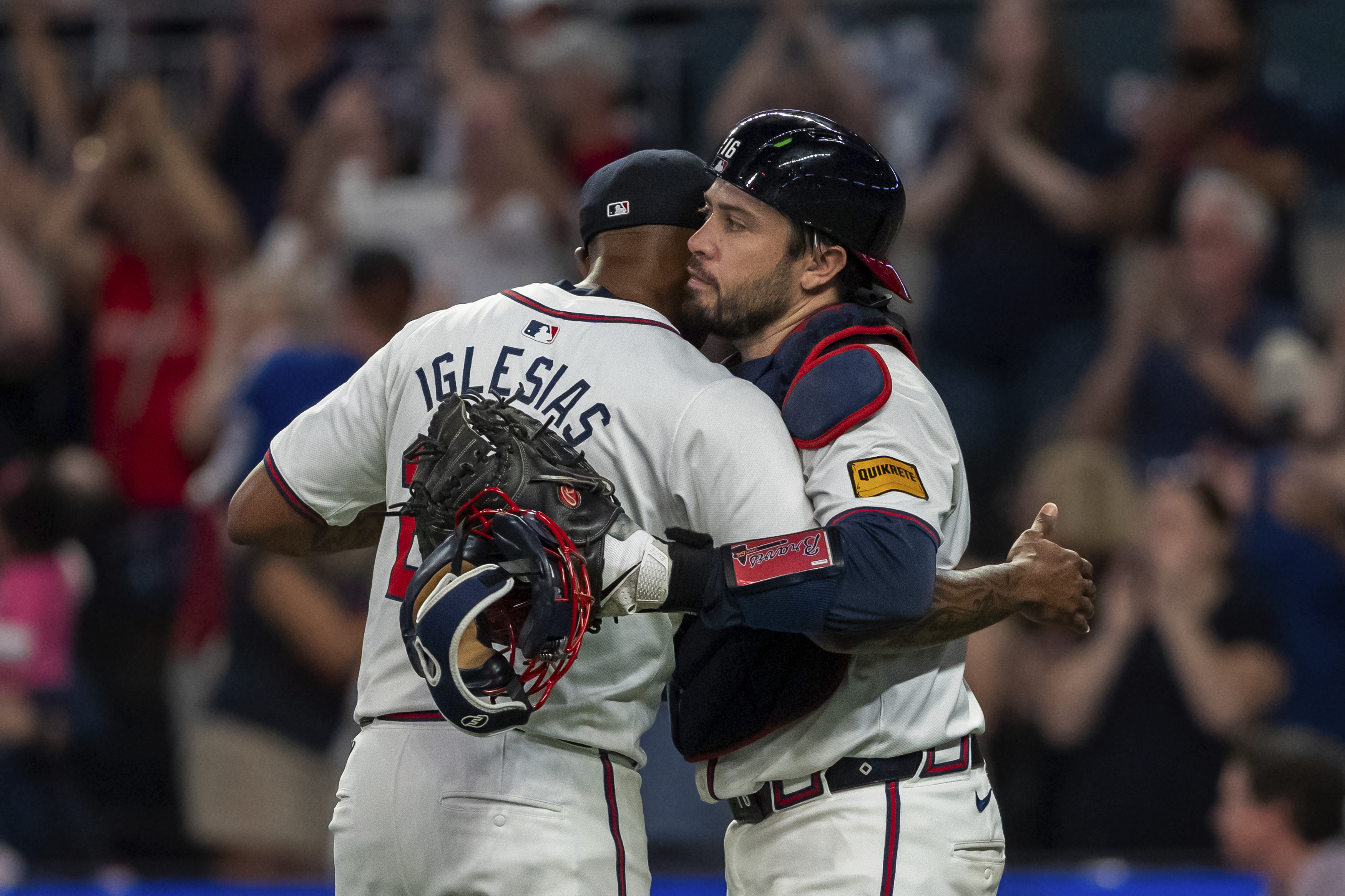 Atlanta Braves pitcher Raisel Iglesias, left, celebrates the win with catcher Travis d'Arnaud, right, following the ninth inning of a baseball game against the New York Mets, Tuesday, Sept. 24, 2024, in Atlanta.