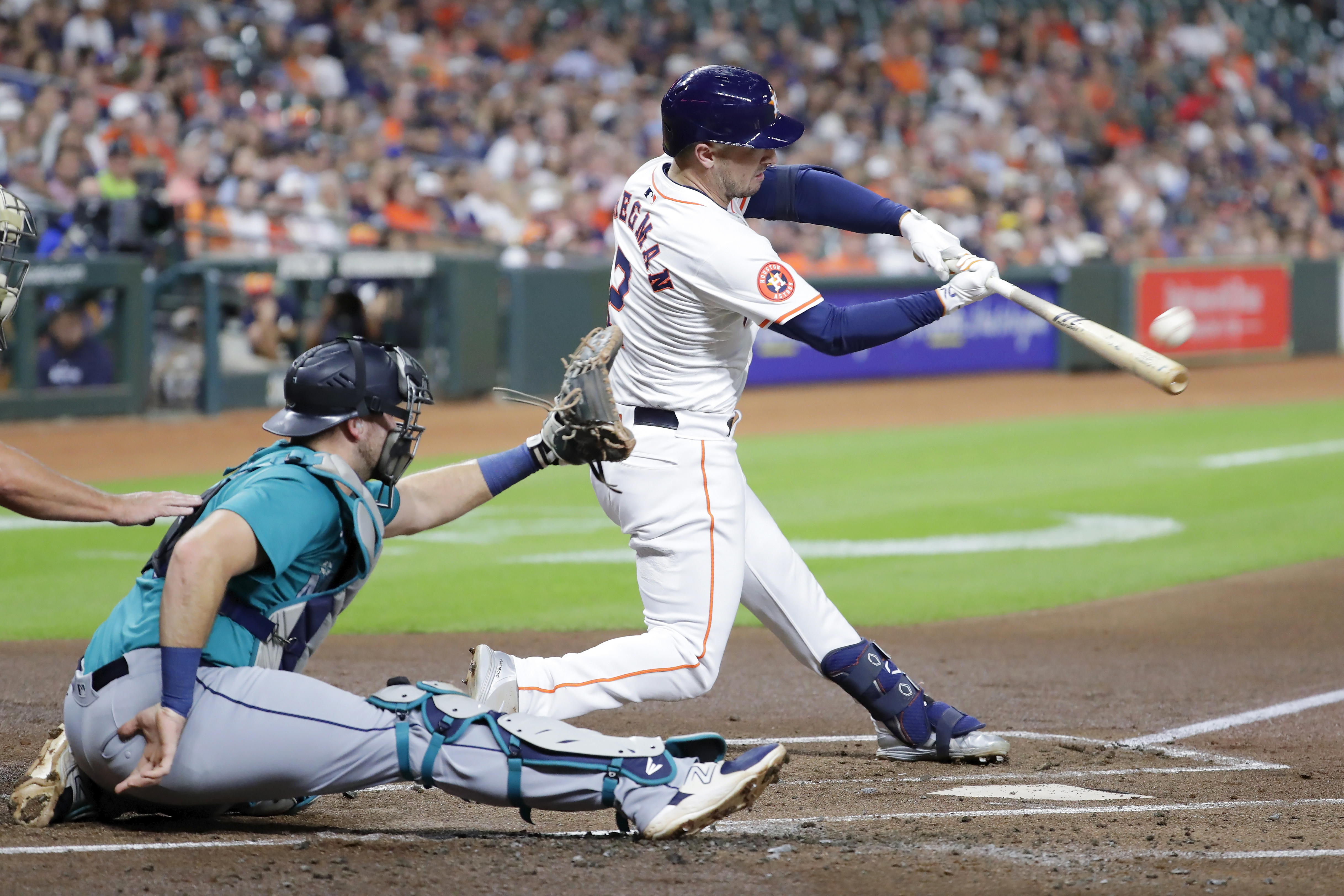 Houston Astros' Alex Bregman (2) connects for a home run in front of Seattle Mariners catcher Cal Raleigh, left, during the first inning of a baseball game Tuesday, Sept. 24, 2024, in Houston. 