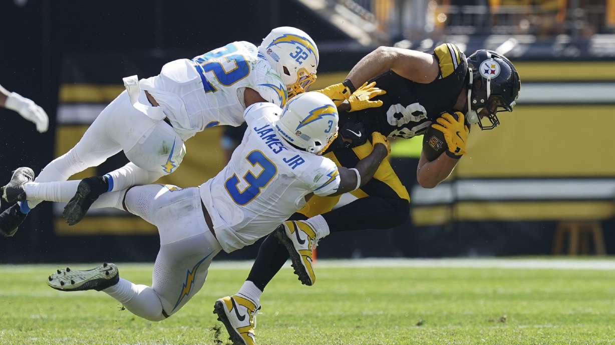 Pittsburgh Steelers tight end Pat Freiermuth, right, is tackled by Los Angeles Chargers safeties Alohi Gilman (32) and Derwin James Jr. during the second half of an NFL football game, Sunday, Sept. 22, 2024, in Pittsburgh.