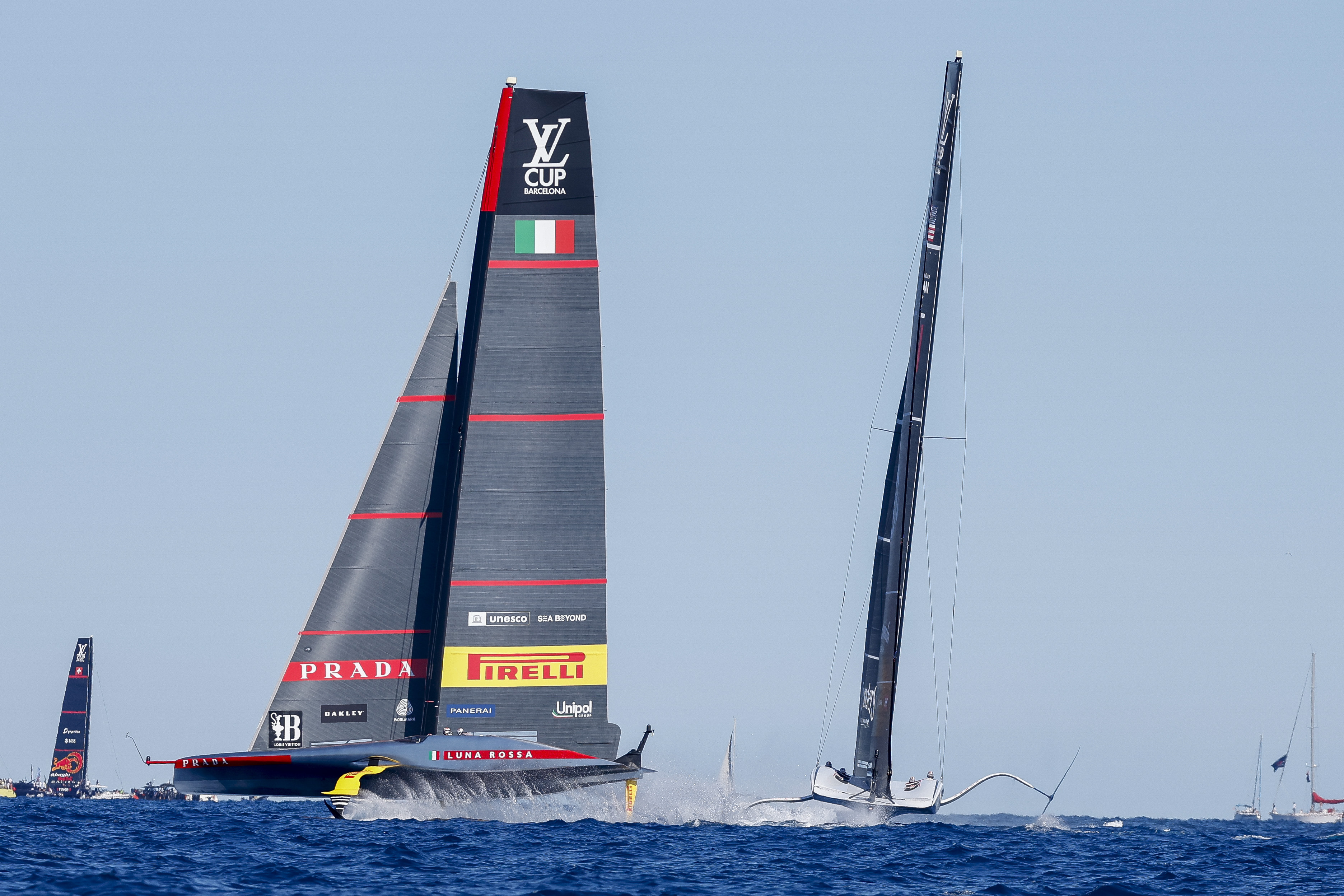Luna Rosa Prada Pirelli Team's AC75, left, and American Magic's AC75 boat sail during Semi-final America's Cup Regatta ahead of the 37th America's Cup sailing race along Barcelona's coast, Spain, Saturday, Sep. 14, 2024. 