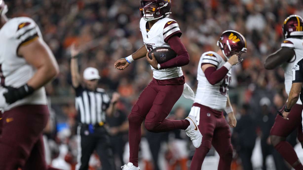 Washington Commanders quarterback Jayden Daniels celebrates after throwing a touchdown pass during the second half of an NFL football game against the Cincinnati Bengals, Monday, Sept. 23, 2024, in Cincinnati.