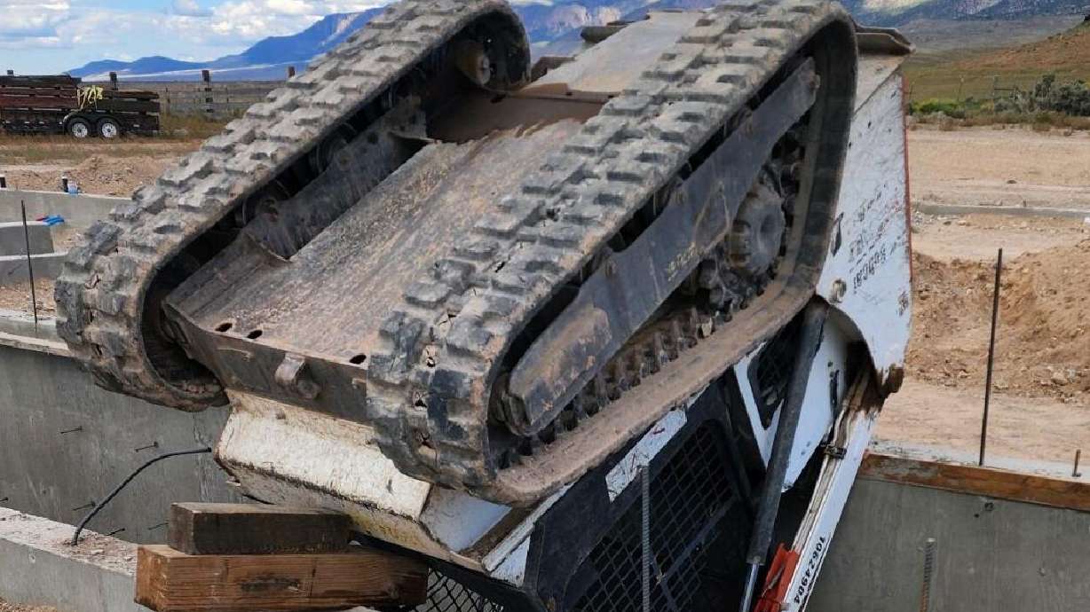 Skid steer vehicle that pinned Keegon Heath sits upside down atop a concrete wall of a home under construction, in the Antimony area, just north of the county line that separates Piute and Garfield counties, Sept. 18.