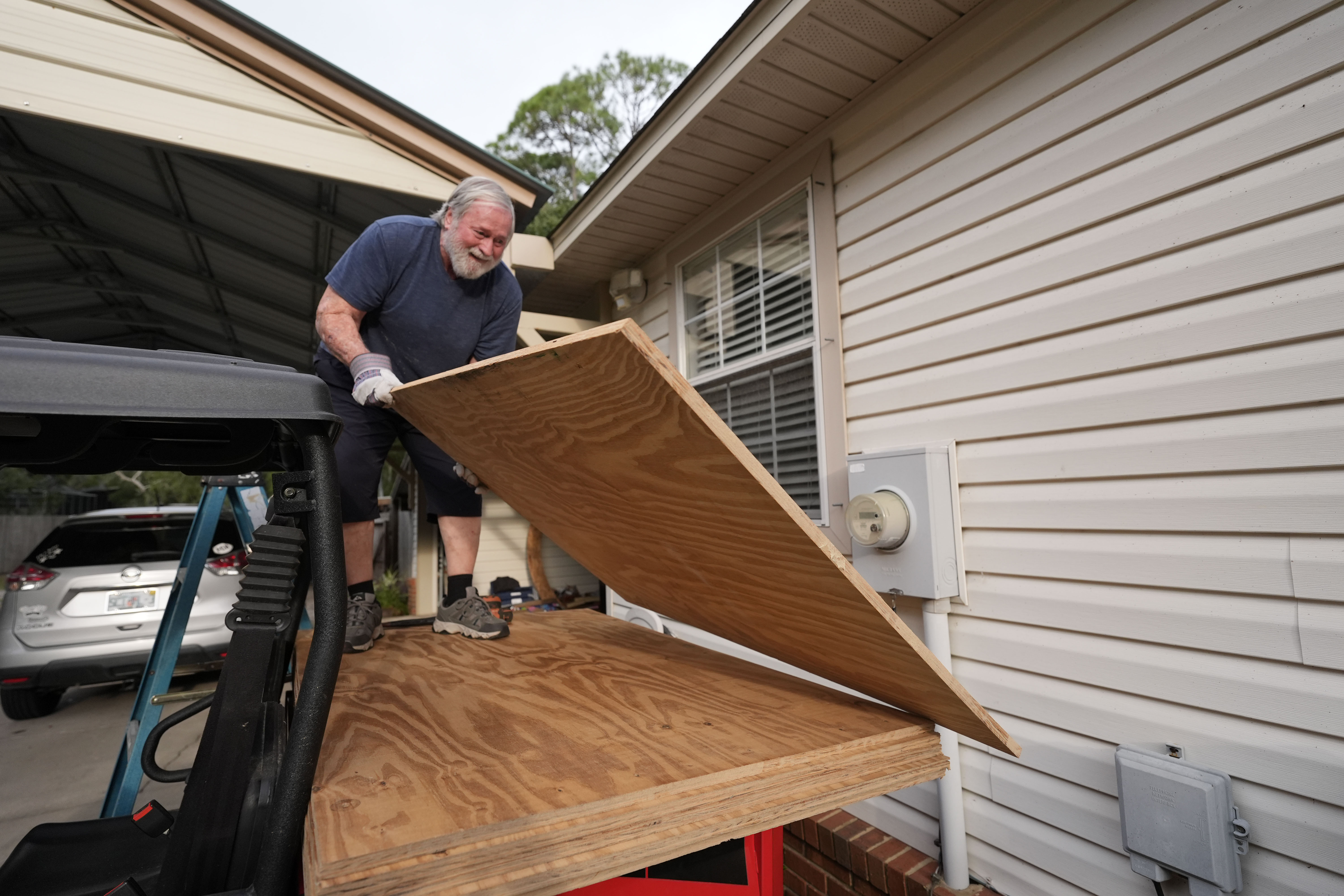 Dave McCurley boards up the windows to his home in advance of Tropical Storm Helene, expected to make landfall as a hurricane, in Ochlockonee Bay, Fla., Wednesday.