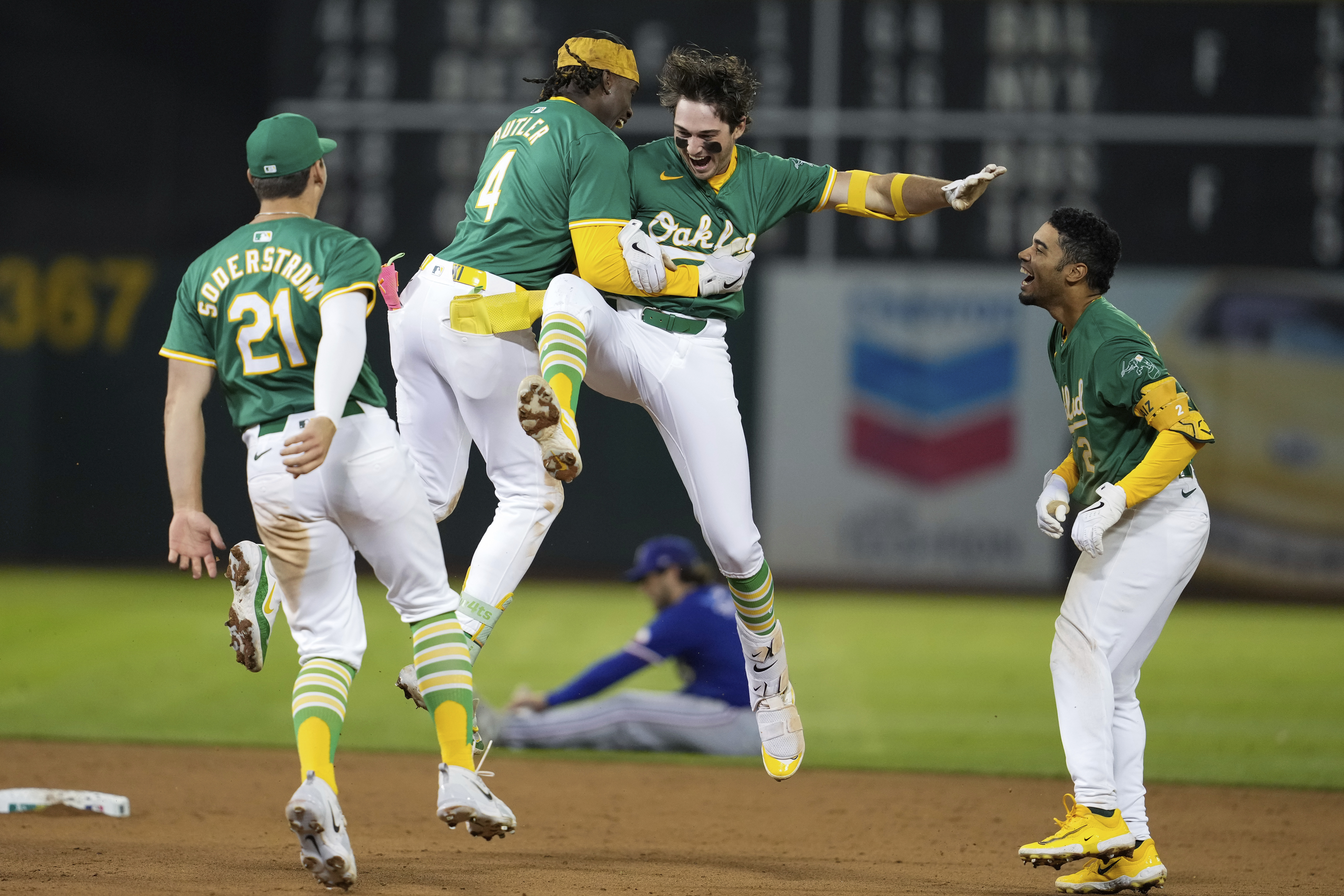 Oakland Athletics' Jacob Wilson, center right, is congratulated by Lawrence Butler (4) after hitting the game-winning RBI single during the ninth inning of a baseball game against the Texas Rangers, Tuesday, Sept. 24, 2024, in Oakland, Calif.