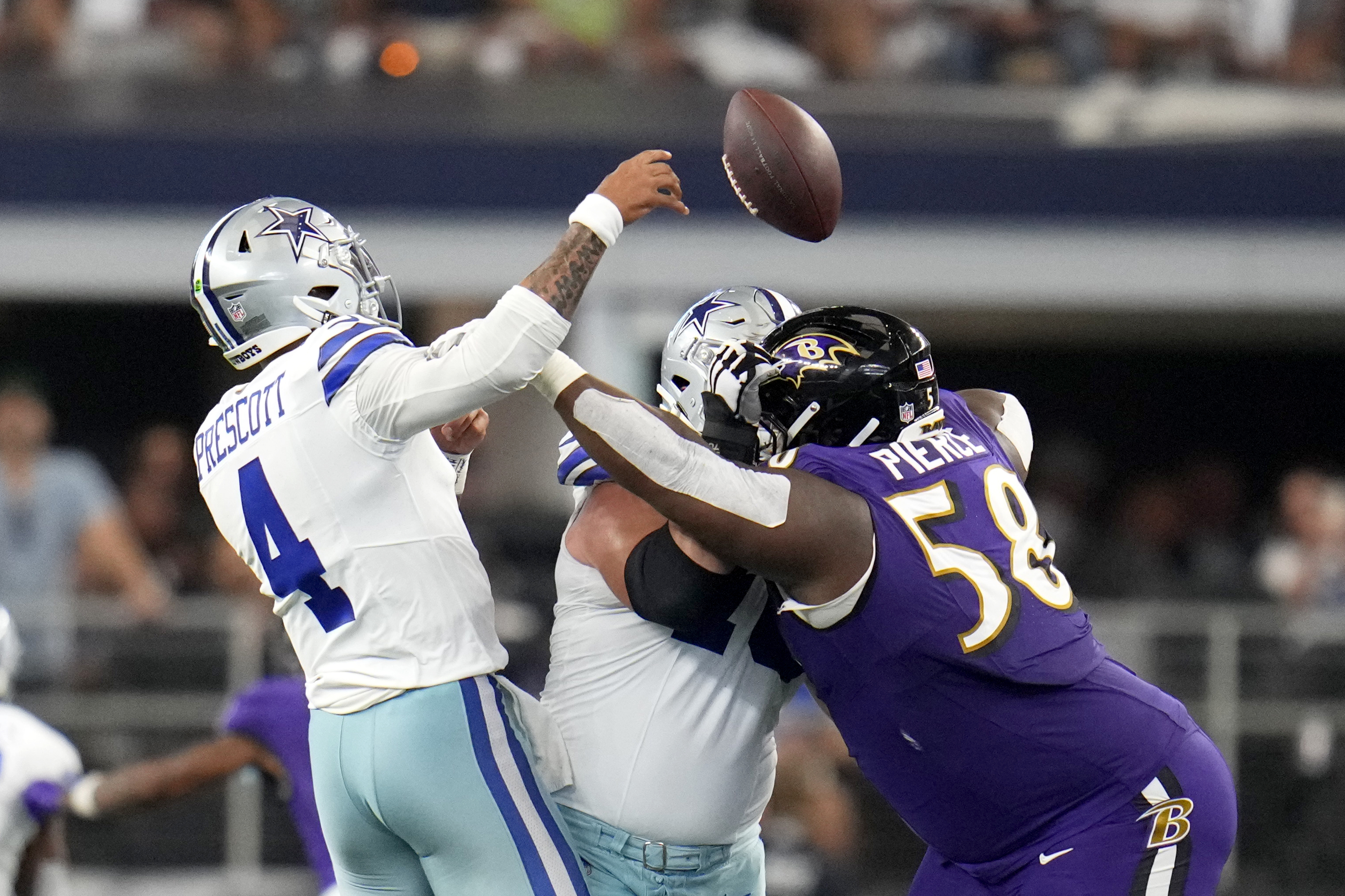 Dallas Cowboys quarterback Dak Prescott (4) is hit trying to throw a pass by Baltimore Ravens defensive tackle Michael Pierce (58) in the second half of an NFL football game in Arlington, Texas, Sunday, Sept. 22, 2024. 