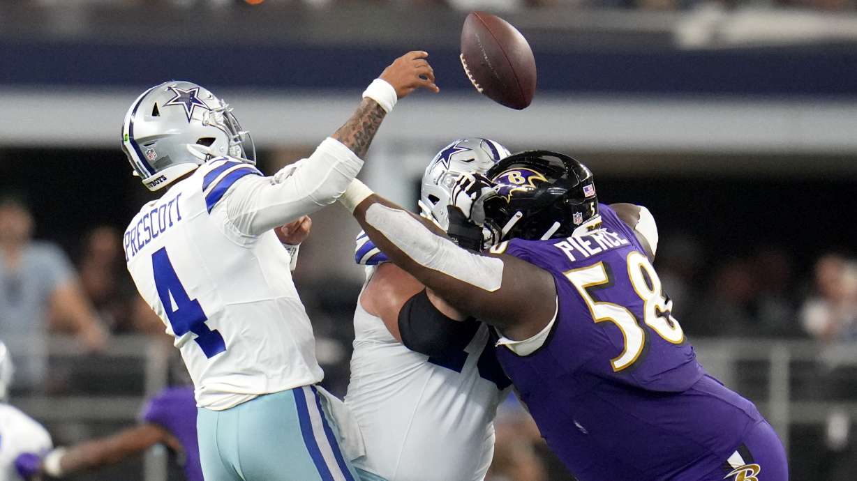 Dallas Cowboys quarterback Dak Prescott (4) is hit trying to throw a pass by Baltimore Ravens defensive tackle Michael Pierce (58) in the second half of an NFL football game in Arlington, Texas, Sunday, Sept. 22, 2024.