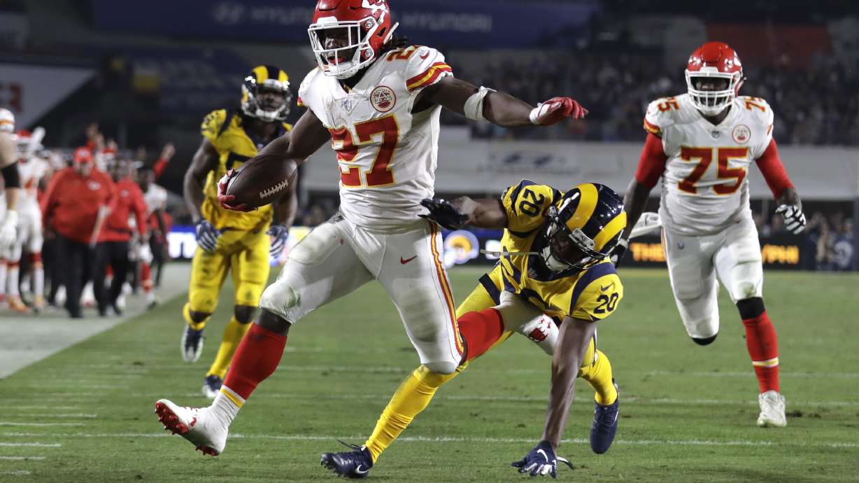 FILE - Kansas City Chiefs running back Kareem Hunt (27) scores a touchdown ahead of Los Angeles Rams free safety Lamarcus Joyner (20) as Chiefs offensive guard Cameron Erving (75) looks on during the first half of an NFL football game, Monday, Nov. 19, 2018, in Los Angeles.