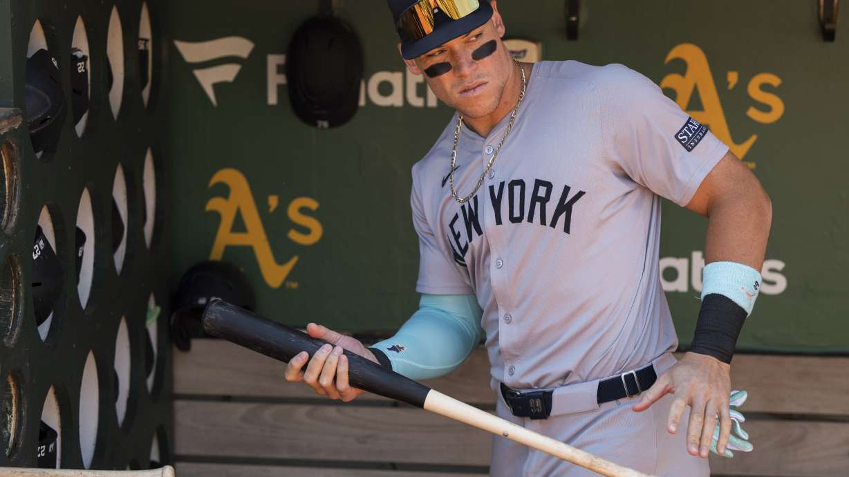 New York Yankees' Aaron Judge grabs a bat from the dugout before a baseball game against the Oakland Athletics in Oakland, Calif., Sunday, Sept. 22, 2024.