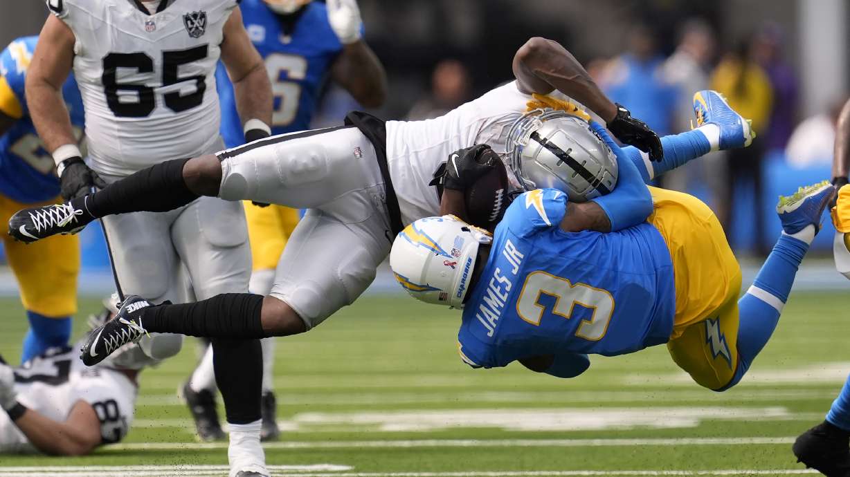 Las Vegas Raiders running back Zamir White, foreground top, is tackled by Los Angeles Chargers safety Derwin James Jr. during the second half of an NFL football game, Sunday, Sept. 8, 2024, in Inglewood, Calif.