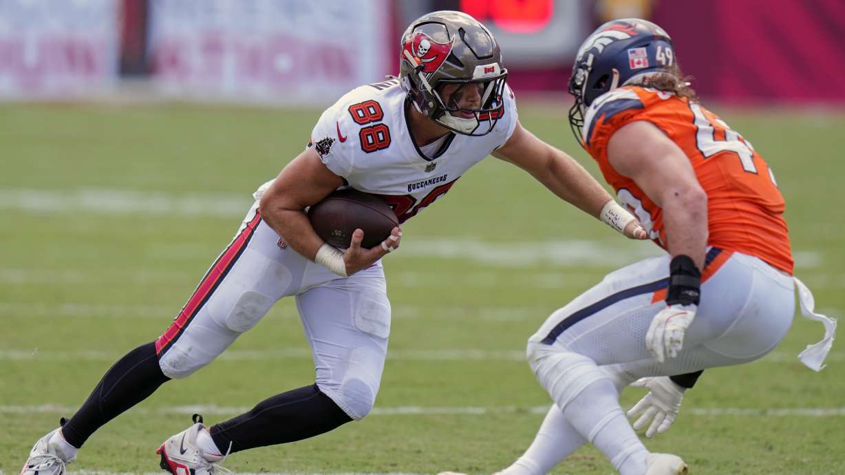 Tampa Bay Buccaneers tight end Cade Otton (88) makes a move to get around Denver Broncos linebacker Alex Singleton, right, after a reception during the first half of an NFL football game, in Tampa, Fla. on Sunday, Sept. 22, 2024.