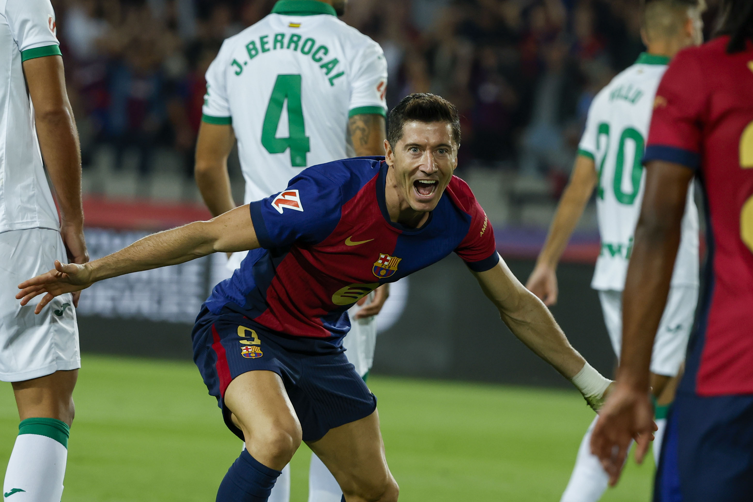 Barcelona's Robert Lewandowski, center, celebrates with Barcelona's Jules Kounde, front, after scoring the opening goal during a Spanish La Liga soccer match between Barcelona and Getafe at the Olympic stadium in Barcelona, Spain, Wednesday, Sept. 25, 2024. 