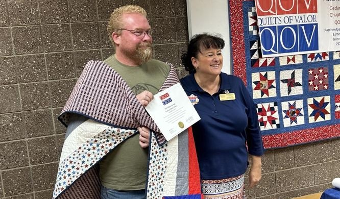 Army veterans Ethan Swapp, left, receives a a certificate from Esmeralda Carter, Quilts of Valor's Iron County group leader in Cedar City on Sept. 13.