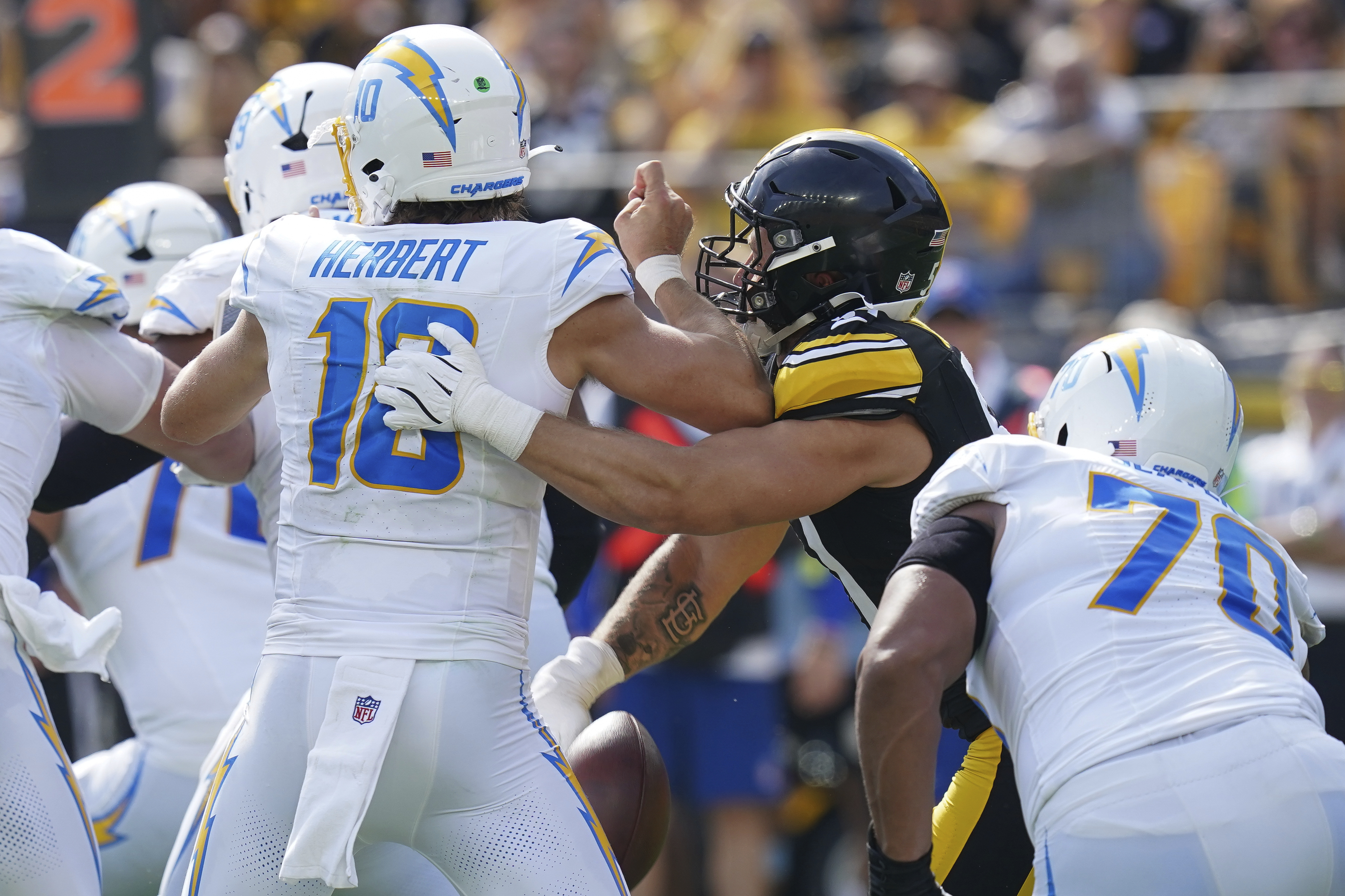 Pittsburgh Steelers linebacker Nick Herbig, second from right, forces a fumble by Los Angeles Chargers quarterback Justin Herbert (10) during the second half of an NFL football game, Sunday, Sept. 22, 2024, in Pittsburgh. 