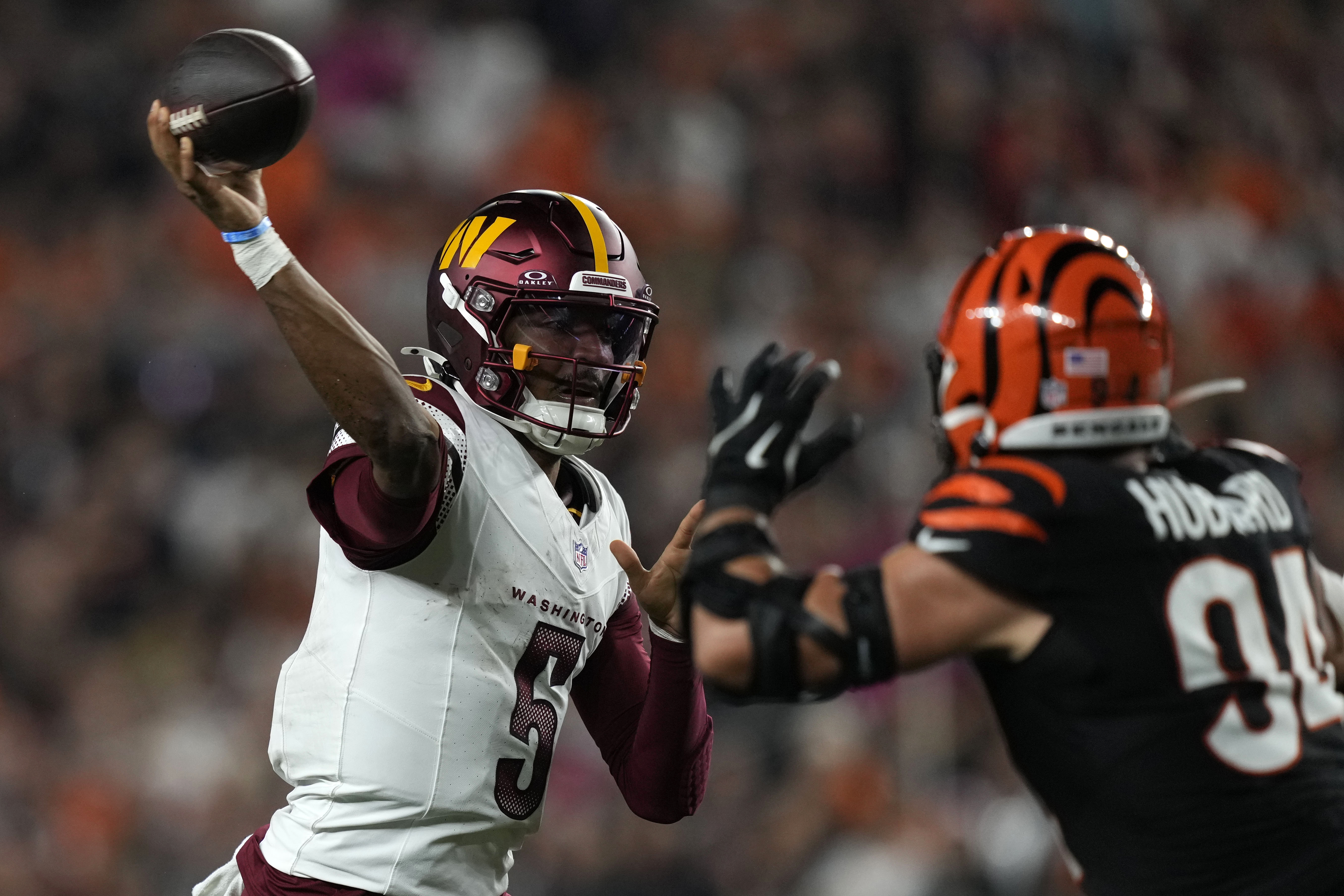 Washington Commanders quarterback Jayden Daniels (5) throws a pass over Cincinnati Bengals defensive end Sam Hubbard (94) during the second half of an NFL football game, Monday, Sept. 23, 2024, in Cincinnati.