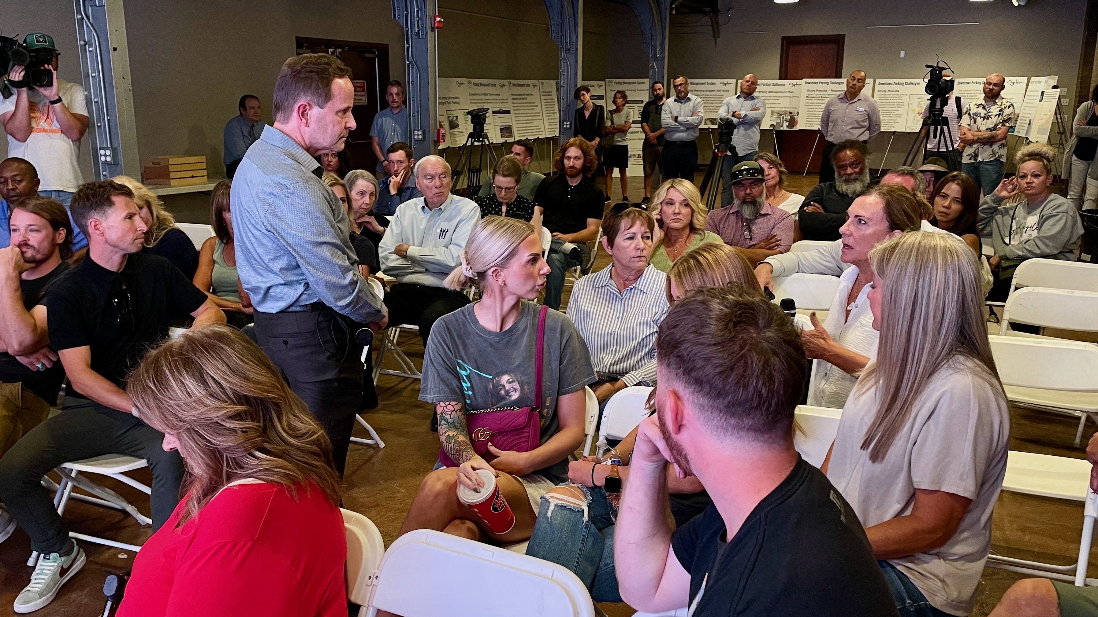 David Sawyer, standing, the deputy executive director of Ogden's Community and Economic Development Department, listens to a comment on controversial plans to implement paid parking in the downtown area at a meeting on Wednesday.