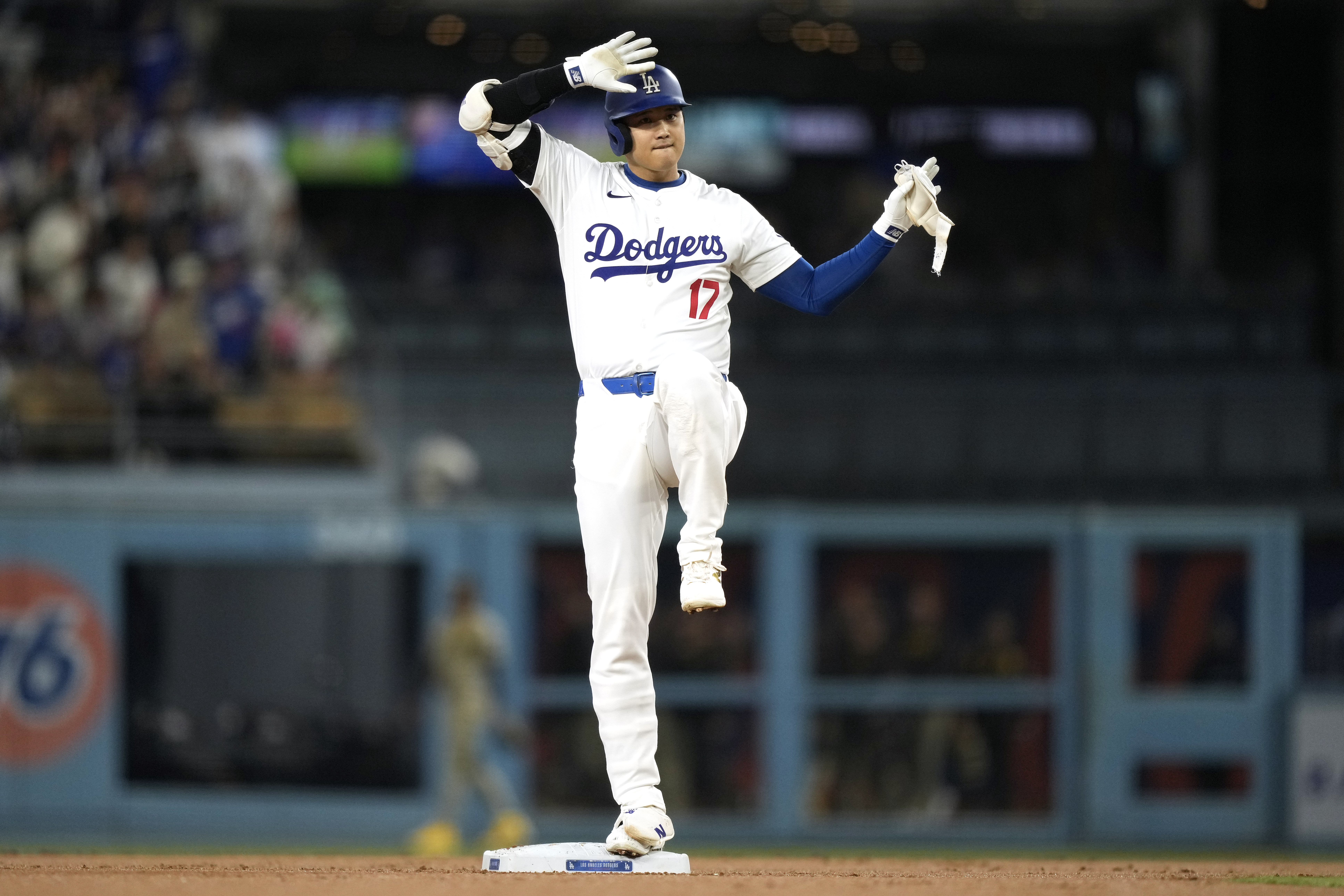 Los Angeles Dodgers' Shohei Ohtani gestures toward his dugout after hitting a double during the first inning of a baseball game against the San Diego Padres, Tuesday, Sept. 24, 2024, in Los Angeles. 