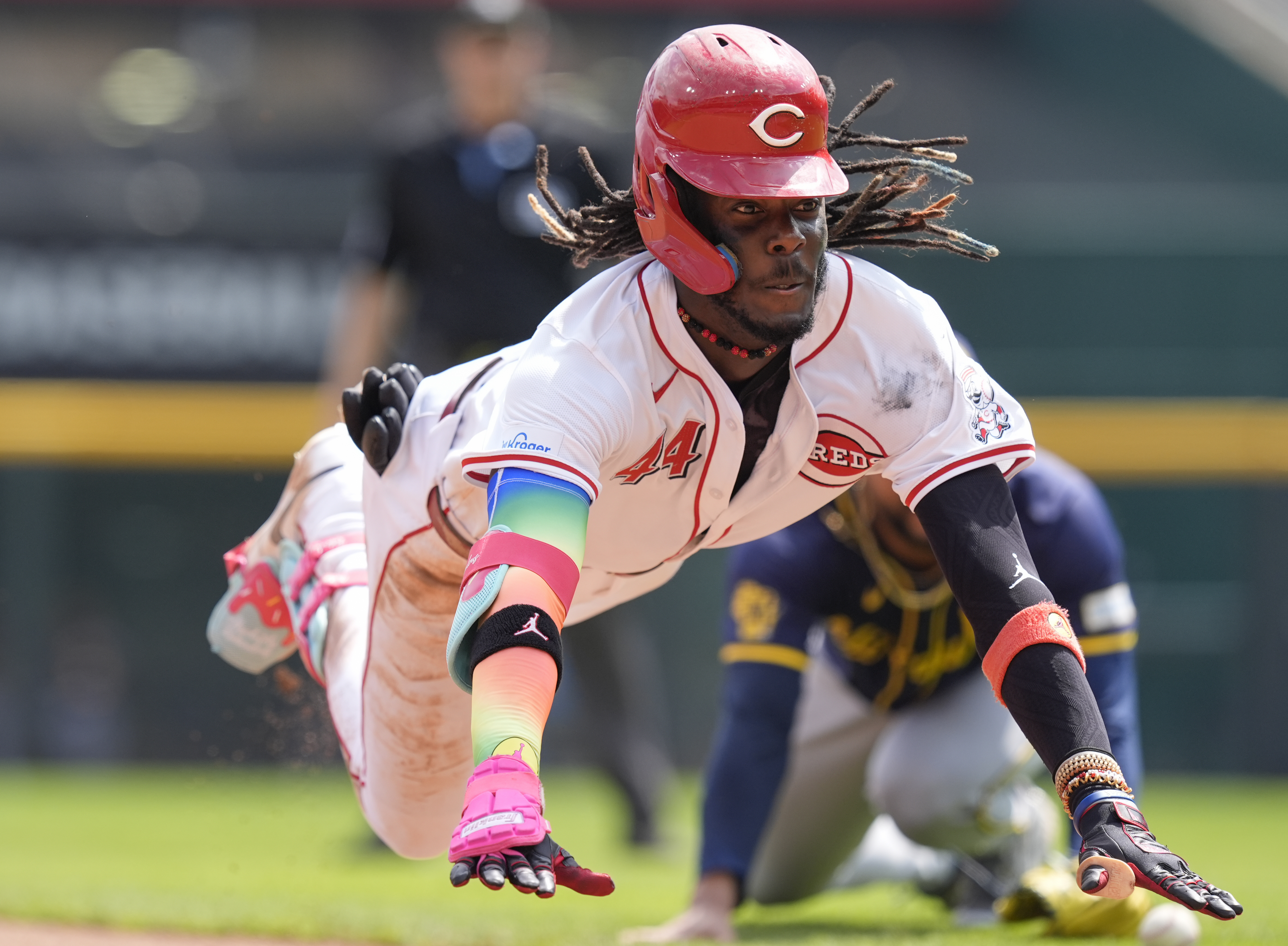 Cincinnati Reds' Elly De La Cruz dives into third as he advances on a throwing error by Milwaukee Brewers right fielder Sal Frelick, after hitting a double during the seventh inning of a baseball game, Friday, Aug. 30, 2024, in Cincinnati. 
