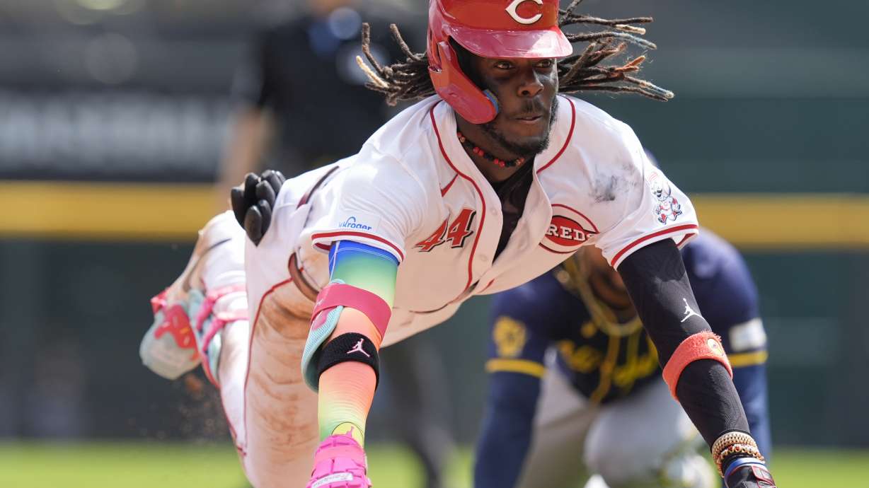 Cincinnati Reds' Elly De La Cruz dives into third as he advances on a throwing error by Milwaukee Brewers right fielder Sal Frelick, after hitting a double during the seventh inning of a baseball game, Friday, Aug. 30, 2024, in Cincinnati.