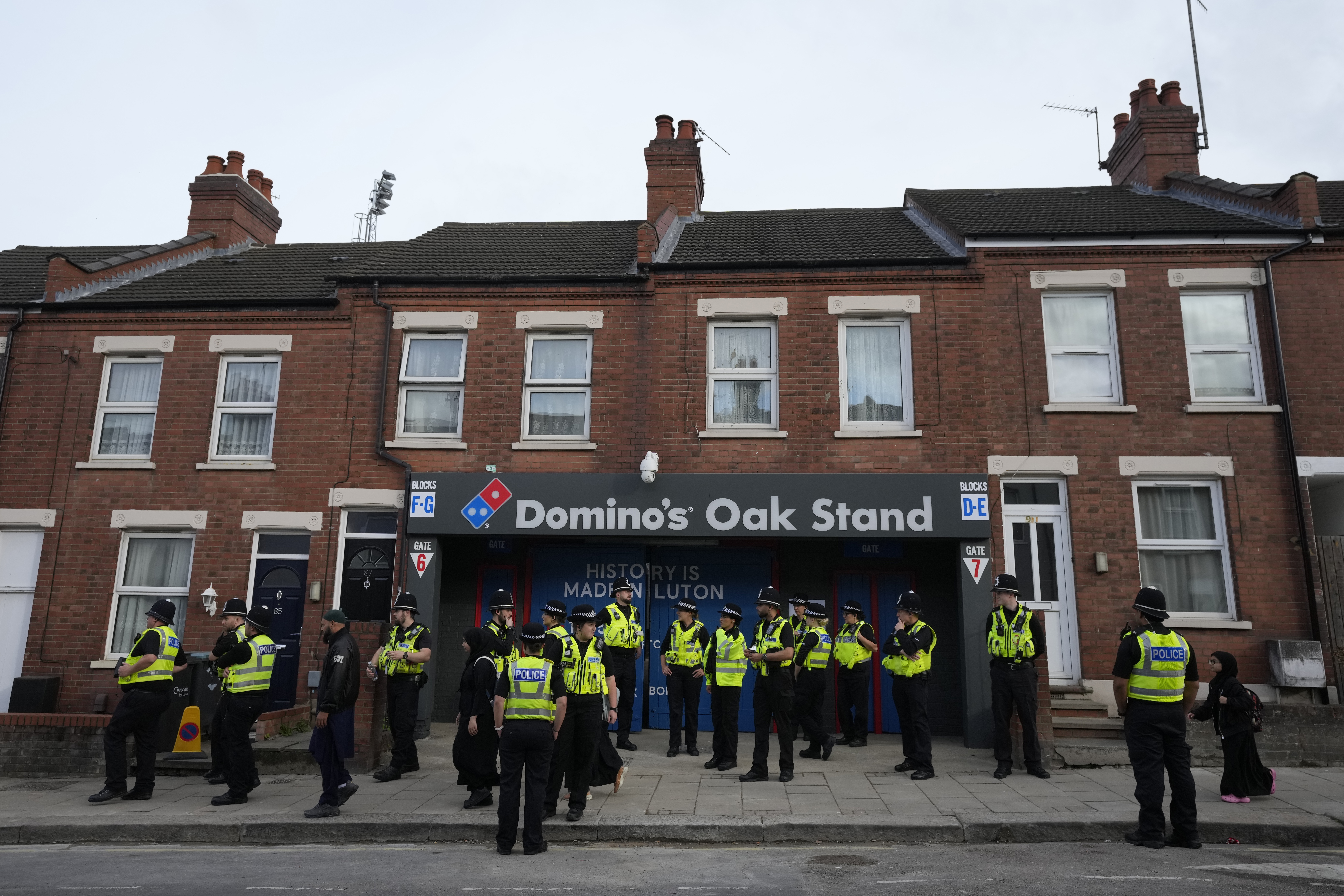 FILE - Police gather outside the Oak Stand entrance to Luton Town ahead of the English Premier League soccer match between Luton Town against West Ham United, in Luton, England, Friday, Sept. 1, 2023. 