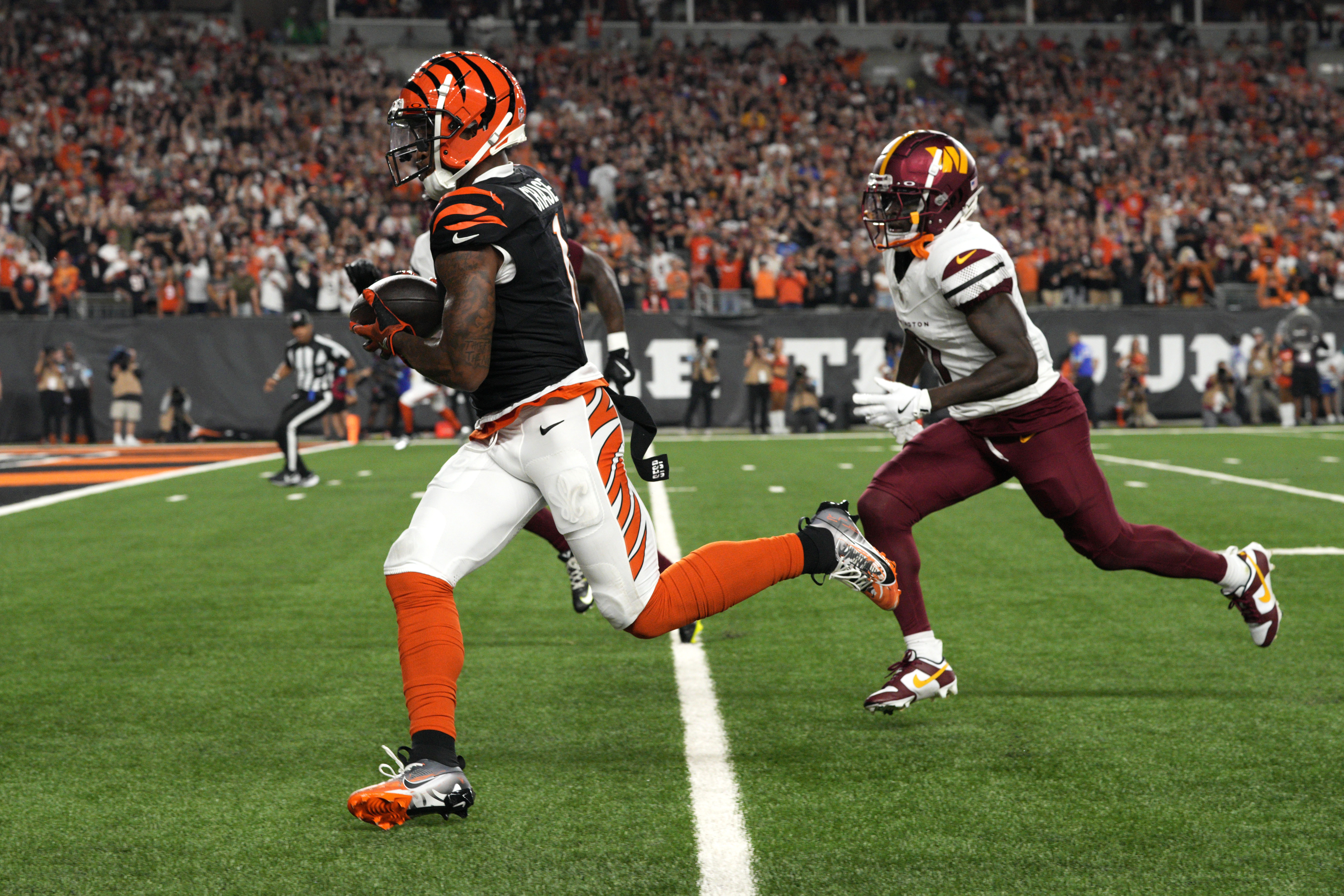 Cincinnati Bengals wide receiver Ja'Marr Chase runs from Washington Commanders cornerback Mike Sainristil, right, during a 41-yard touchdown reception in the first half of an NFL football game, Monday, Sept. 23, 2024, in Cincinnati. 