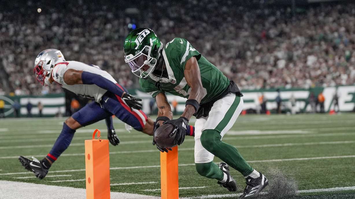 New York Jets wide receiver Garrett Wilson (5) scores a touchdown against the New England Patriots during the third quarter of an NFL football game, Thursday, Sept. 19, 2024, in East Rutherford, N.J.
