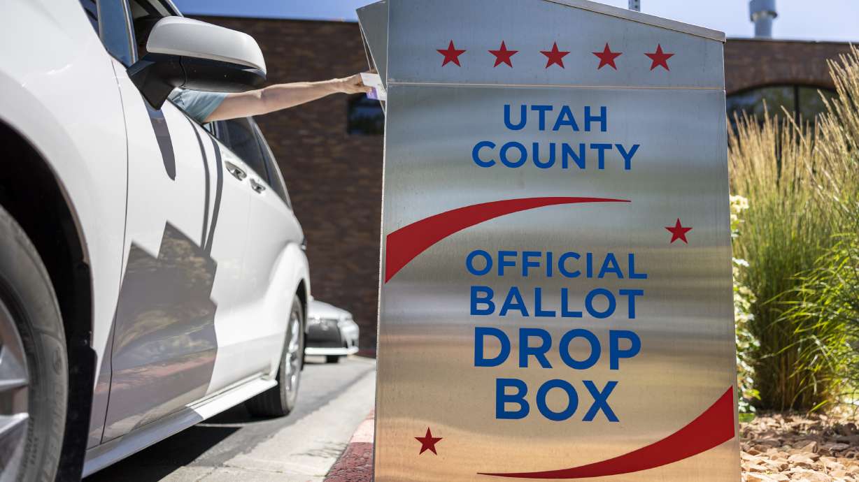 A voter drops their ballot in a ballot drop box during primary election voting at the Orem Public Library in Orem on June 25, 2024.