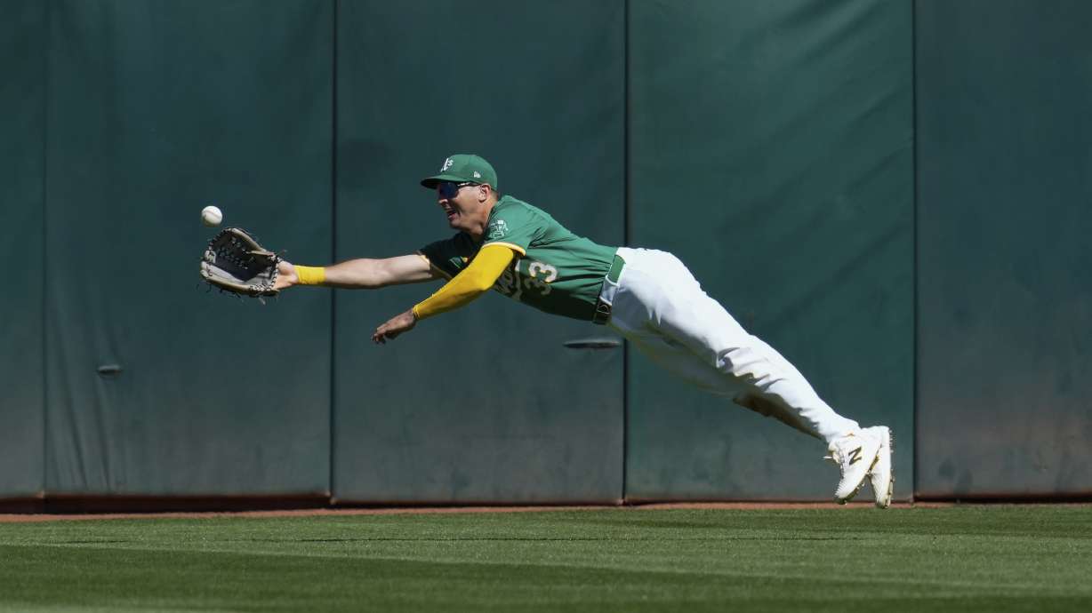 Oakland Athletics center fielder JJ Bleday makes a diving catch on a fly ball hit by Texas Rangers' Carson Kelly during the seventh inning of a baseball game Thursday, Sept. 26, 2024, in Oakland, Calif.