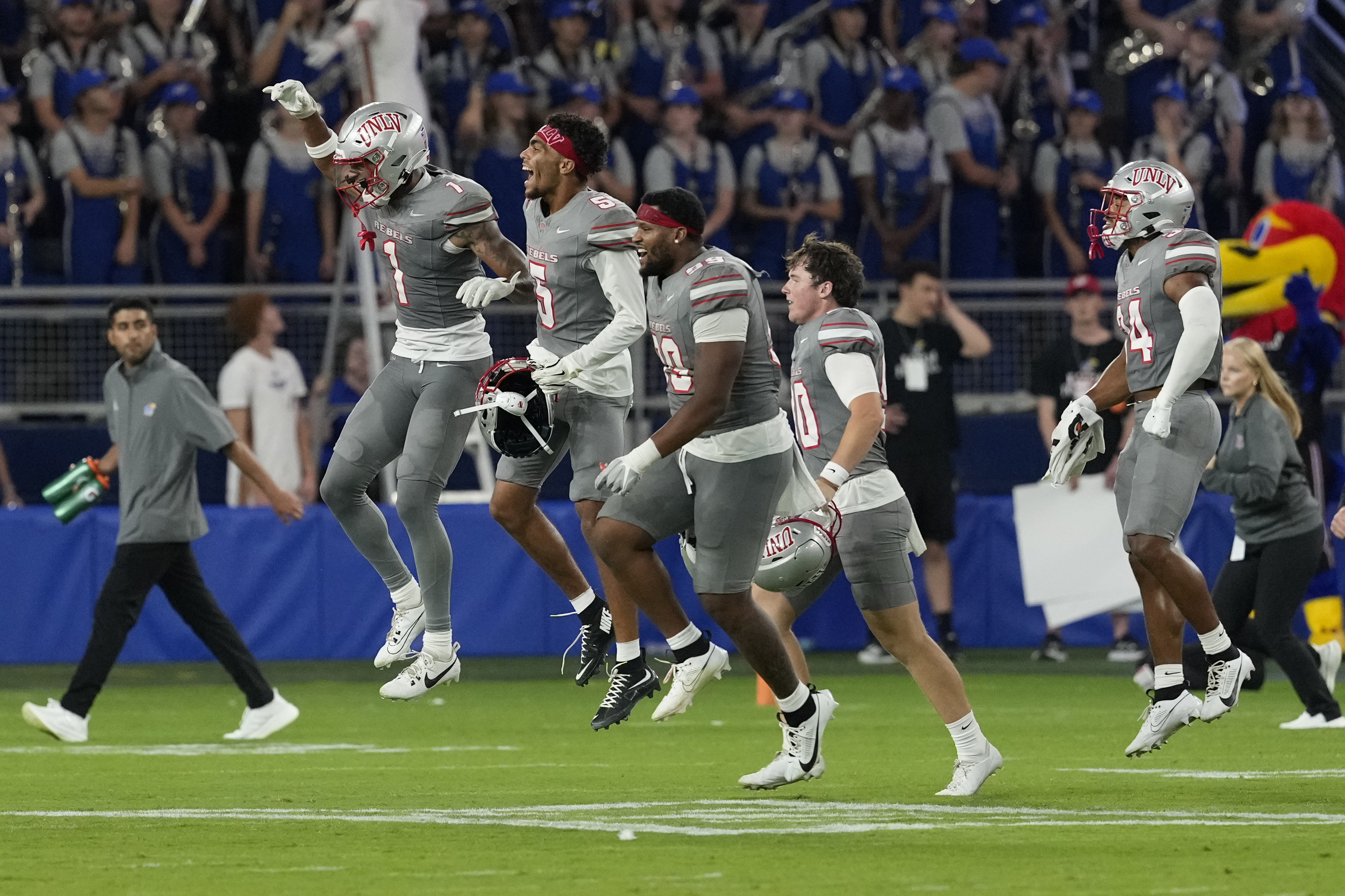 Members of UNLV run onto the field after a 23-20 win over Kansas during an NCAA college football game, Friday, Sept. 13, 2024, at Children's Mercy Park in Kansas City, Kan. 