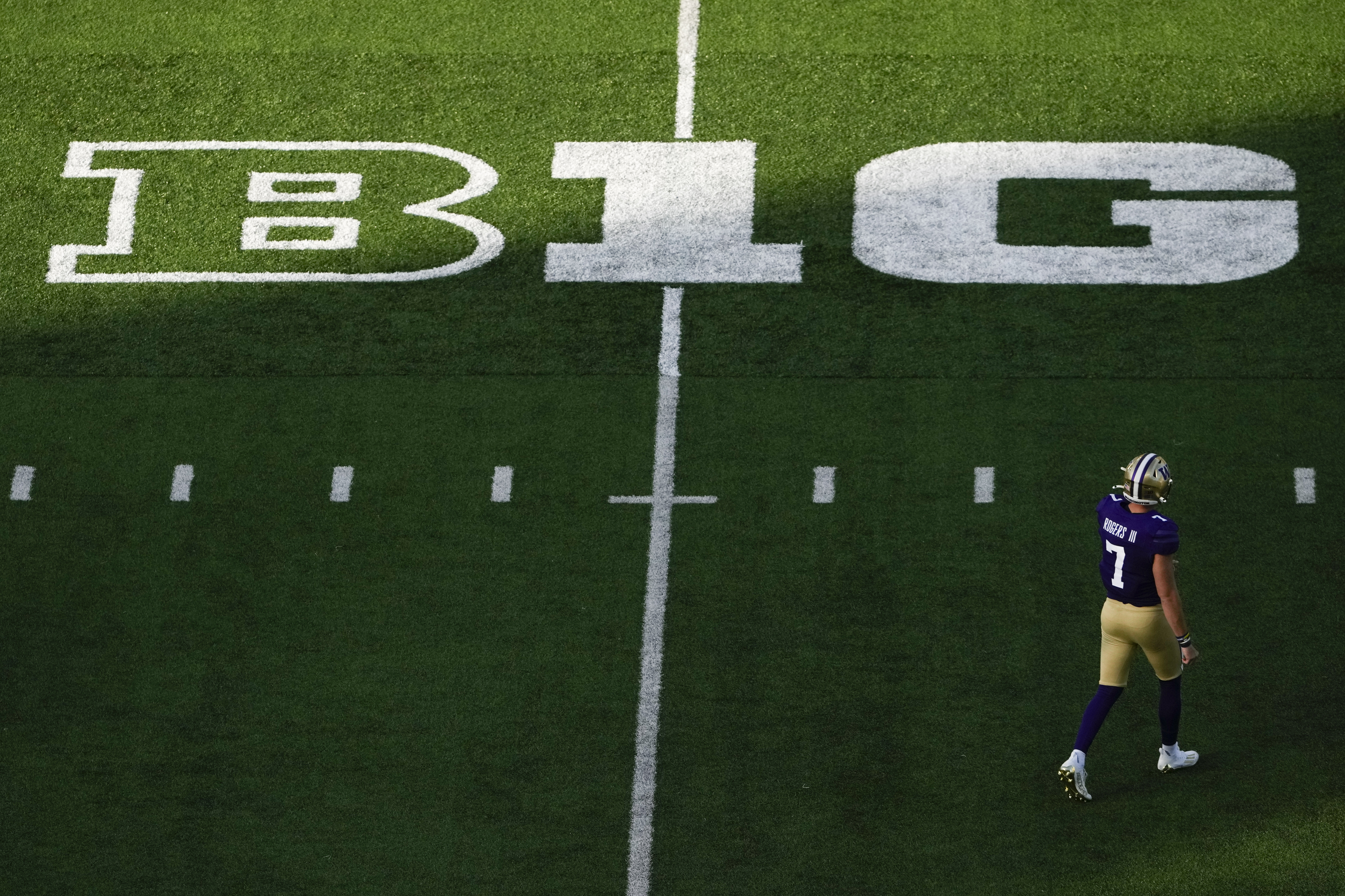 Washington quarterback Will Rogers walks on the field near a Big Ten logo during the first half of an NCAA college football game against Northwestern, Saturday, Sept. 21, 2024, in Seattle.