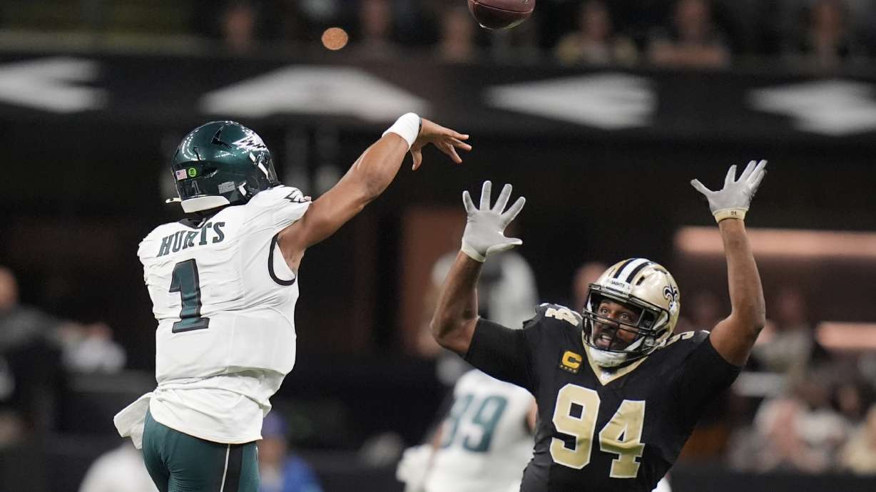 Philadelphia Eagles quarterback Jalen Hurts (1) passes over the reach of New Orleans Saints defensive end Cameron Jordan (94) in the second half of an NFL football game in New Orleans, Sunday, Sept. 22, 2024.