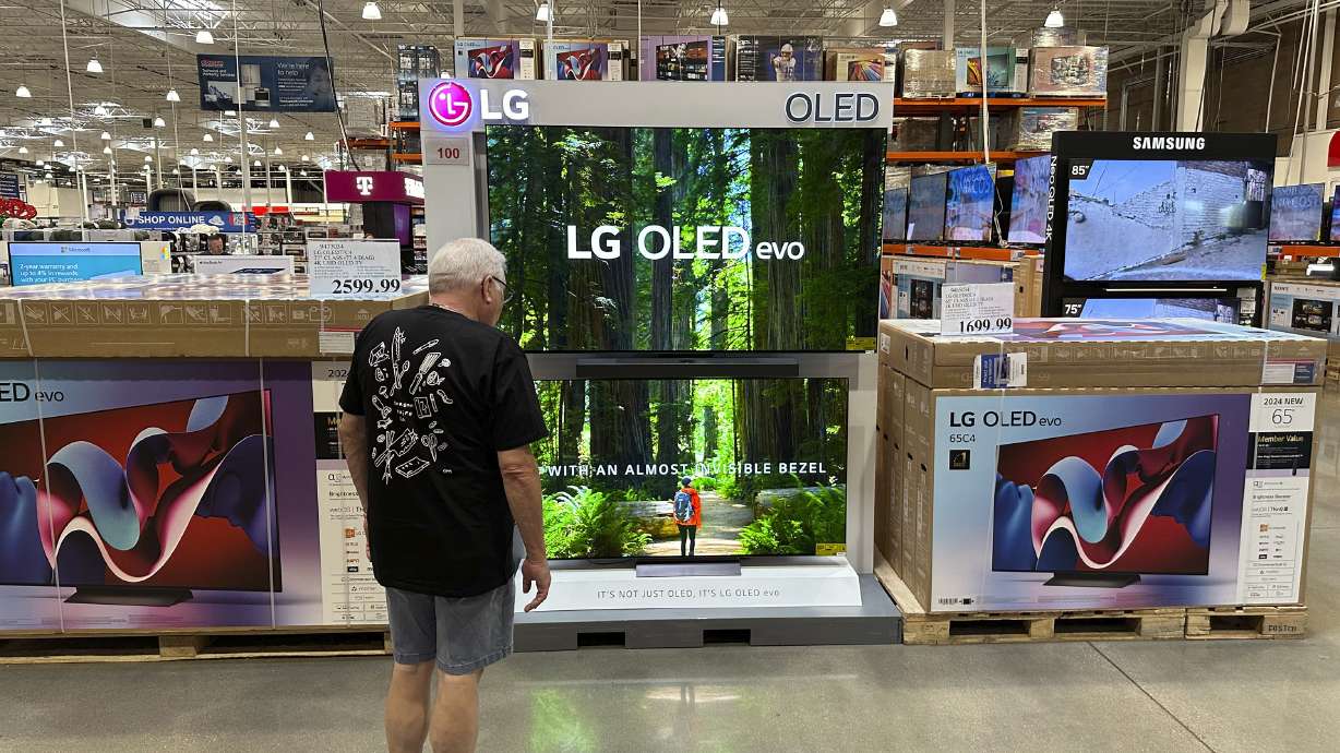 A shopper examines large-screen televisions on display in a Costco warehouse Sept. 19, in Lone Tree, Colo. The Federal Reserve's preferred inflation measure provided the latest sign that price pressures are easing.