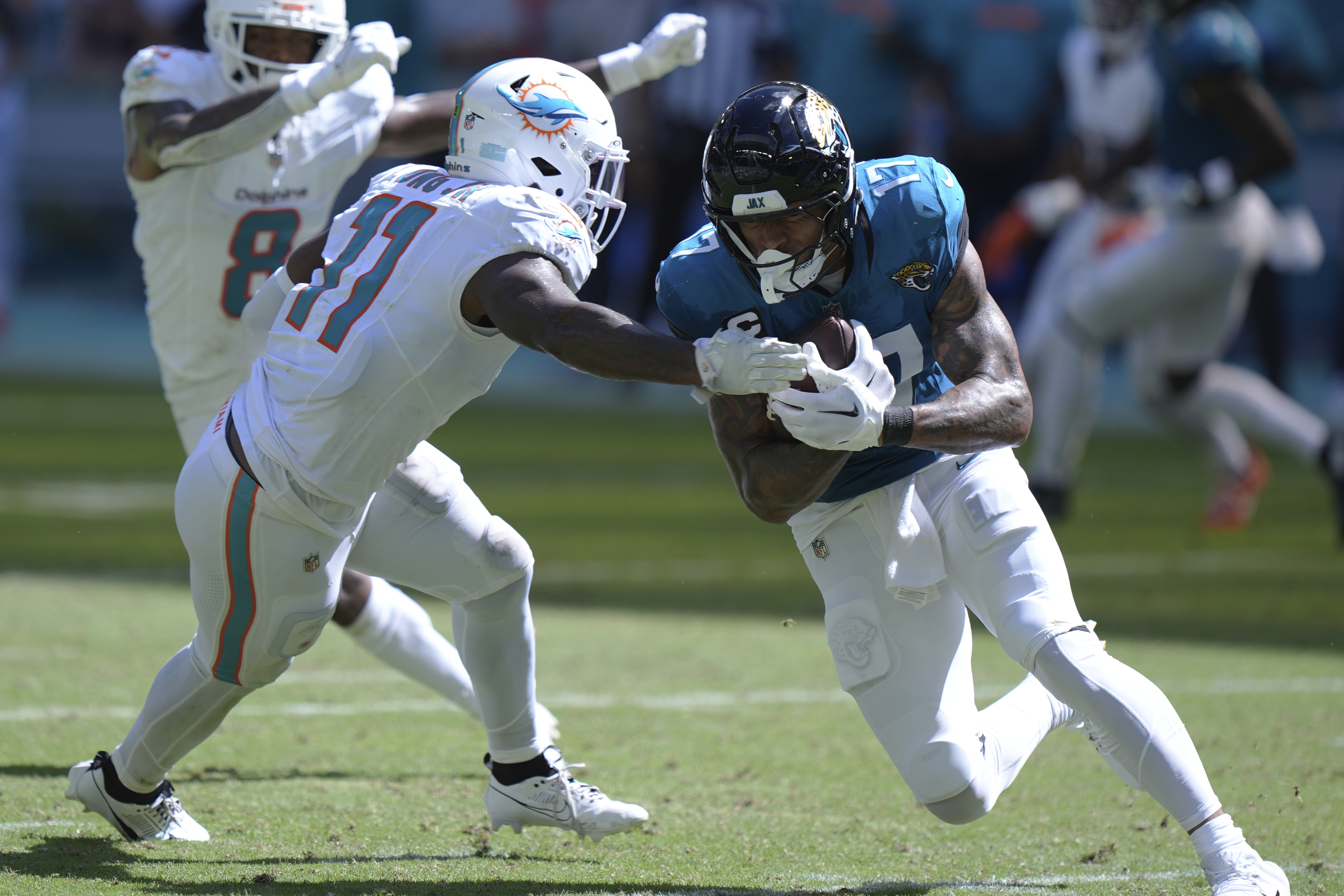 Jacksonville Jaguars tight end Evan Engram (17) runs with the football as Miami Dolphins linebacker David Long Jr. (11) attempts to stop him during the second half of an NFL football game, Sunday, Sept. 8, 2024, in Miami Gardens, Fla. 