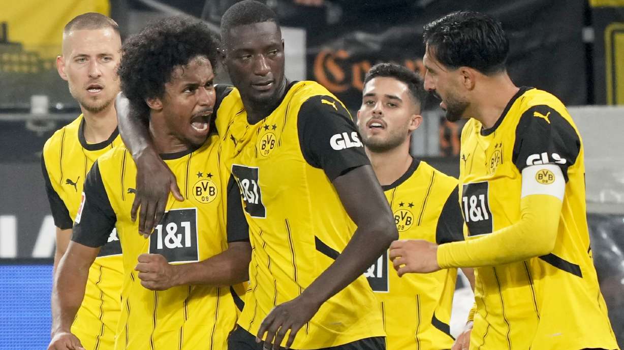 Dortmund's Serhou Yadaly Guirassi, center, celebrates with Karim Adeyemi, 2nd left, and Emre Can, right, after scoring his side's third goal during the German Bundesliga soccer match between Borussia Dortmund and VfL Bochum at Westfalenstadion in Dortmund, Germany, Friday, Sept. 27, 2024.
