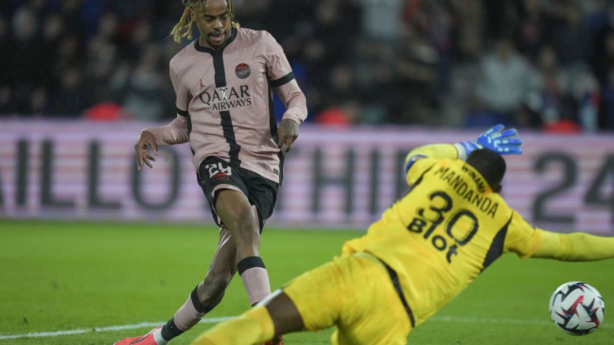 PSG's Bradley Barcola, left, scores his side's third goal during the French League One soccer match between Paris Saint-Germain and Rennes at the Parc des Princes in Paris, Friday, Sept. 27, 2024.