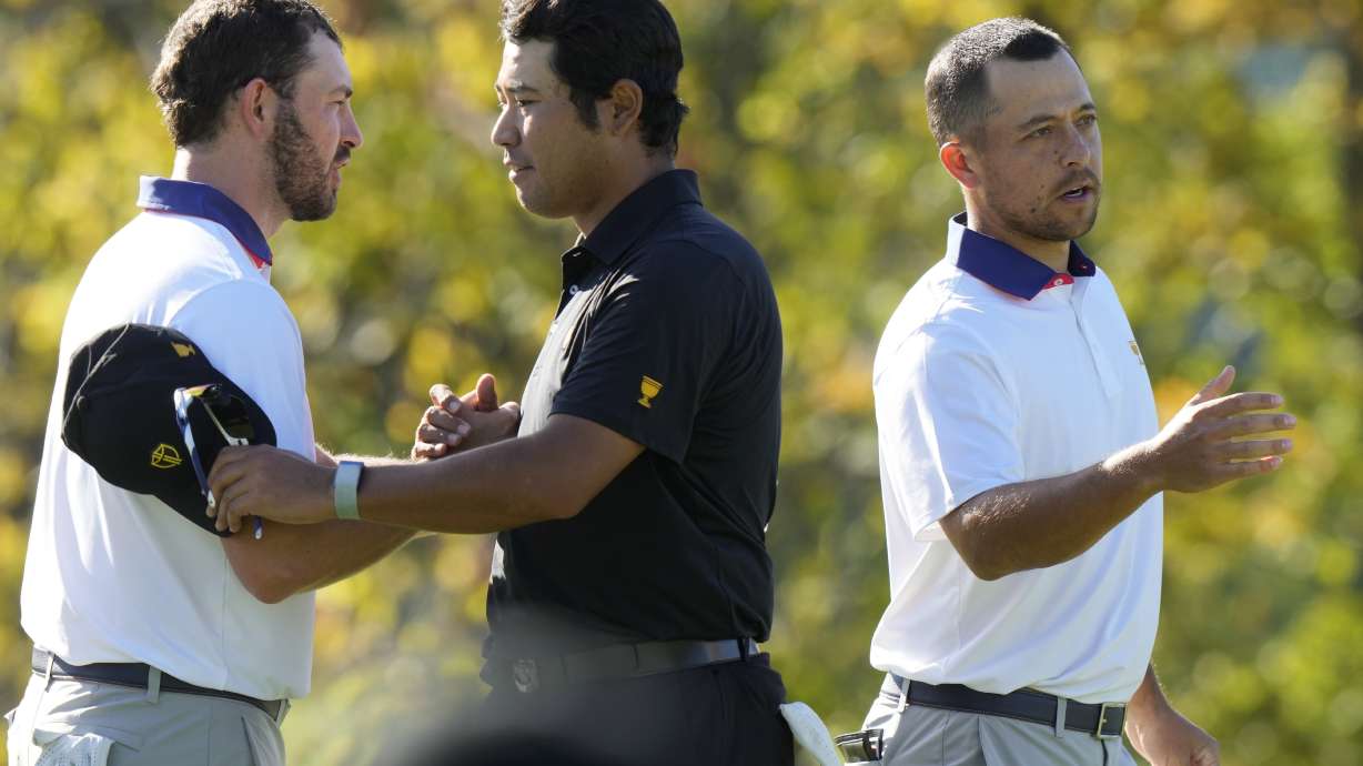 International team member Hideki Matsuyama of Japan shakes hands with United States team members Russell Henley, left, and Xander Schauffele, right, after winning their second round foursome match 7&6 at the Presidents Cup golf tournament at Royal Montreal Golf Club Friday, Sept. 27, 2024 in Montreal.