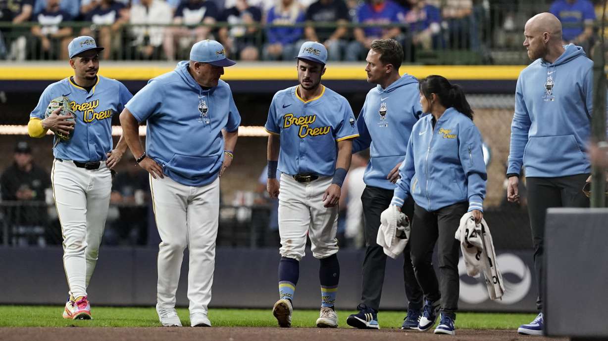 Milwaukee Brewers' Sal Frelick, center, walks off the field during the third inning of a baseball game against the New York Mets, Friday, Sept. 27, 2024, in Milwaukee. Frelick left the game after suffering an injury.