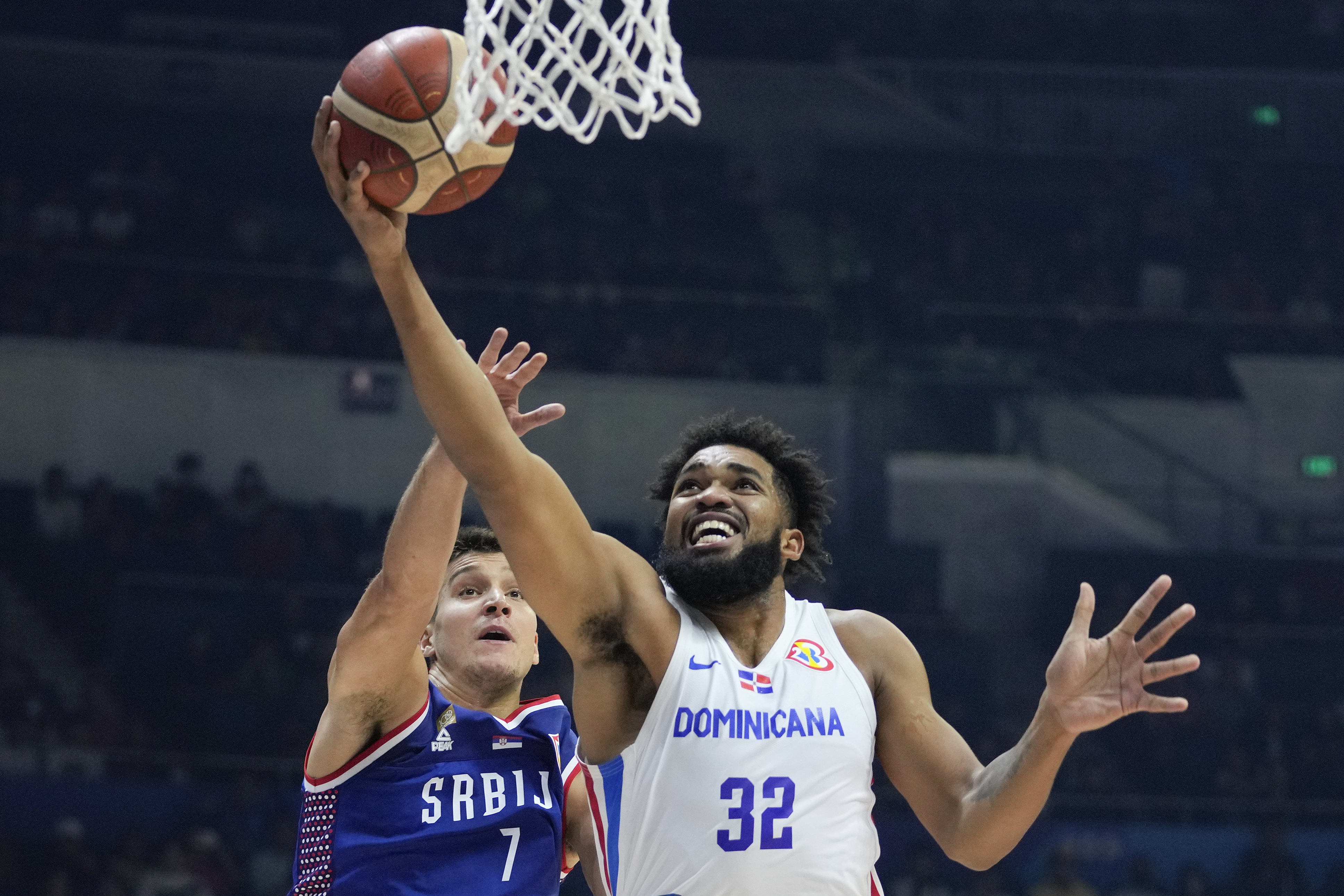 FILE - Dominican Republic forward Karl-Anthony Towns (32) against Serbia guard Bogdan Bogdanovic (7) during their Basketball World Cup second round match at the Araneta Coliseum, Manila, Philippines on Sunday Sept. 3, 2023.
